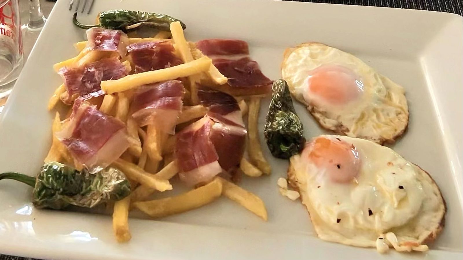Patatas fritas con jamón, huevo y pimientos del padrón