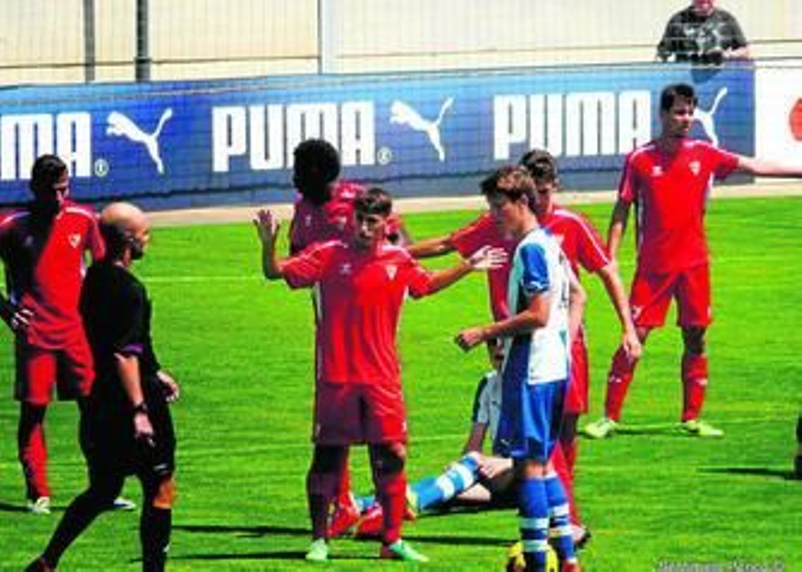 El árbitro del encuentro se dirige al sevillista Juanje y a Lirola en el área del Sevilla.