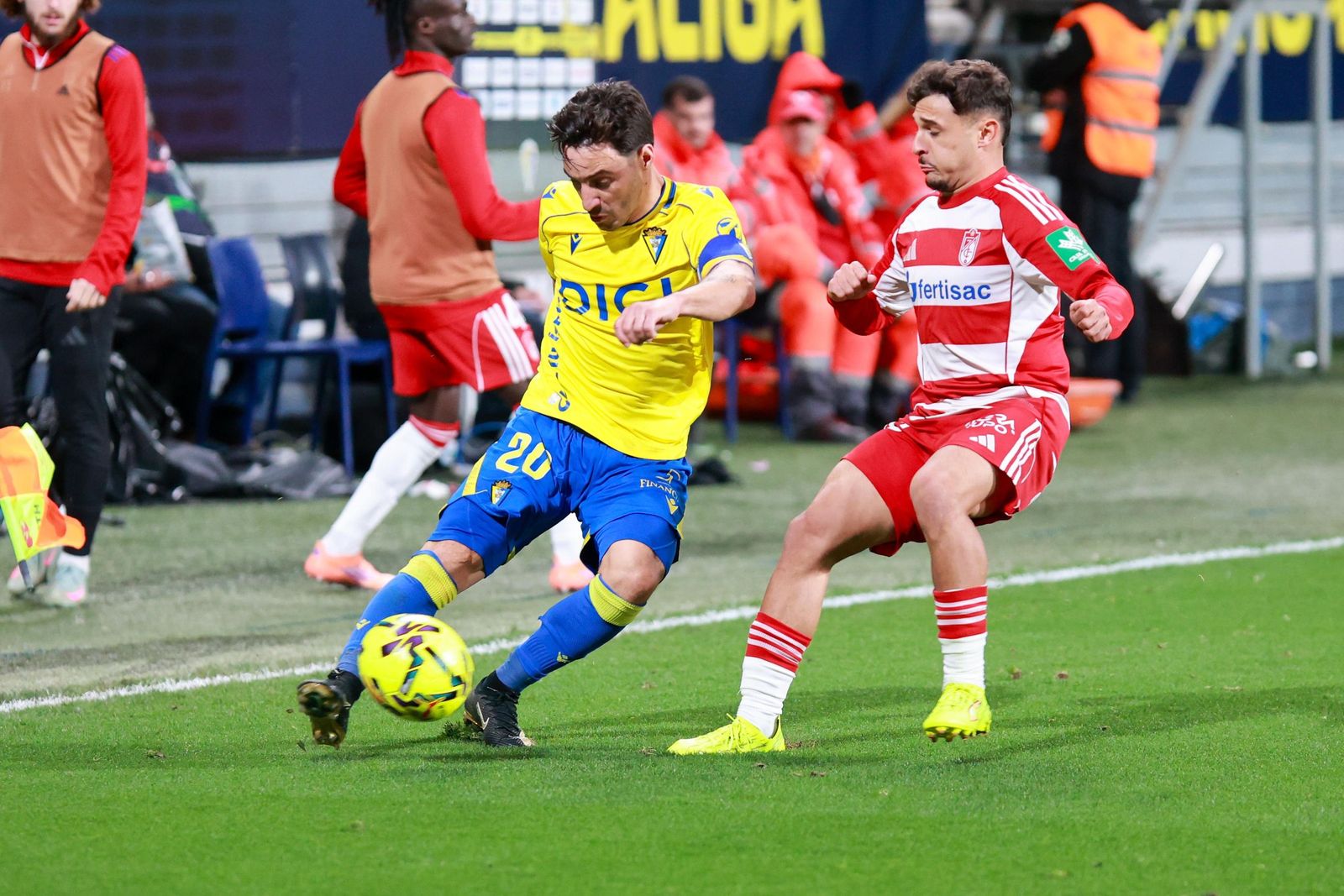 Iza Carcelén golpea el balón ante el acoso de un jugador del Granada.