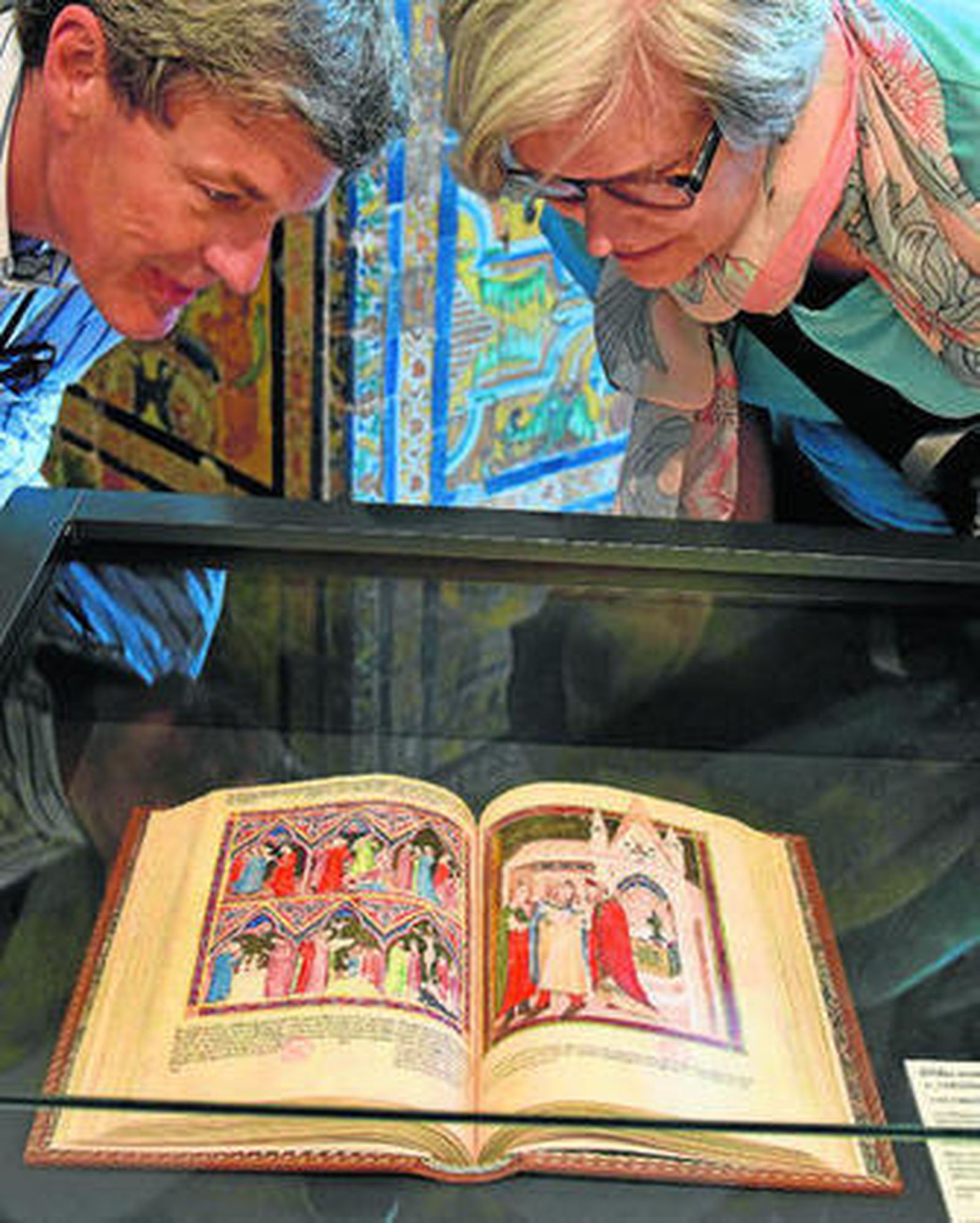 1. Dos visitantes observan la 'Biblia Moralizada de Nápoles' (1340-1350). Con 384 páginas y 204 miniaturas, ofrece uno de los más raros y excepcionales ejemplares de la pintura napolitana. 2. Ejemplar del 'Apocalipsis' (1313). 162 miniaturas iluminadas con oro. Imágenes excepcionales por su abundancia y calidad.