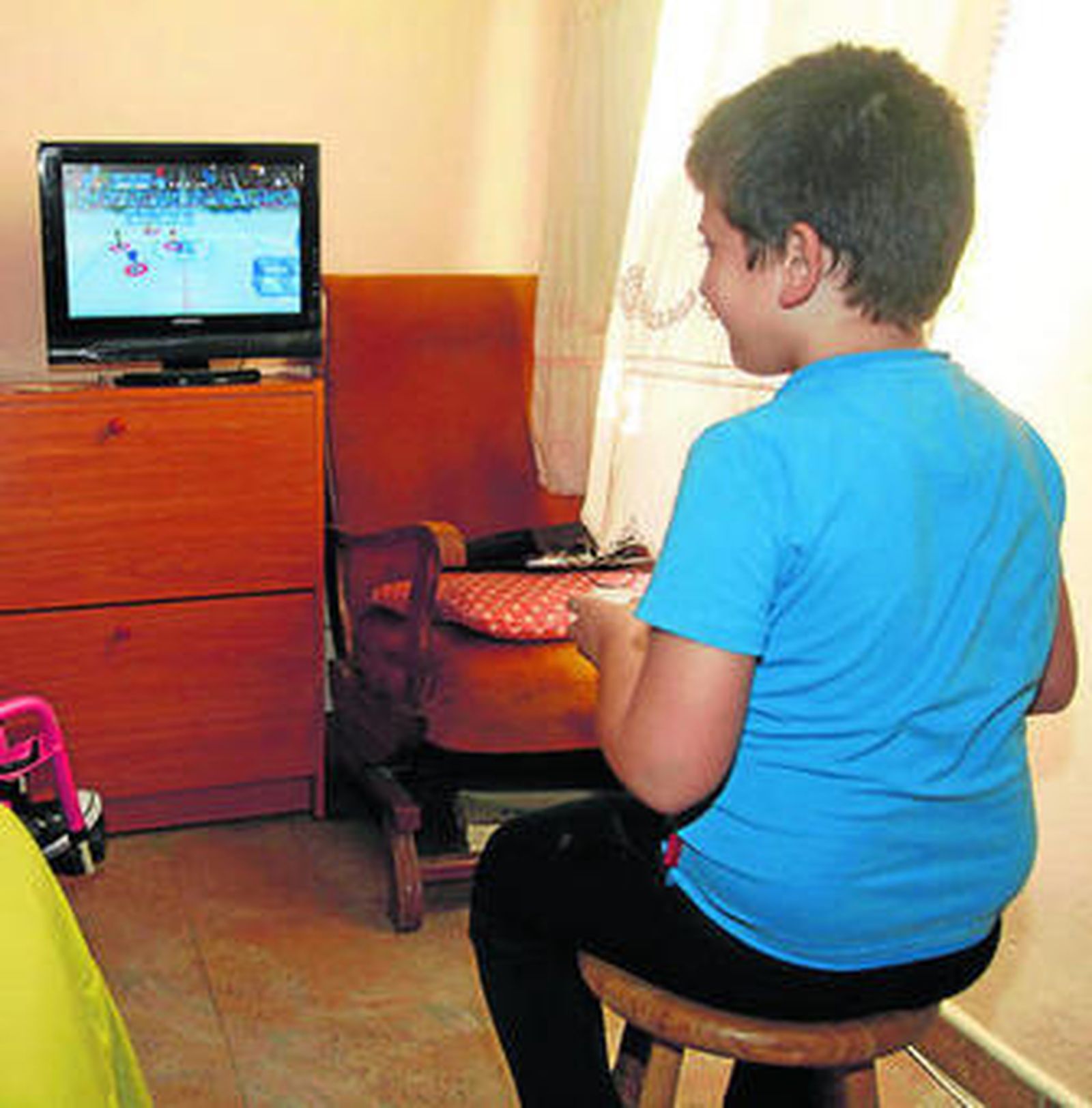 Un niño ve la televisión en el salón de su casa.