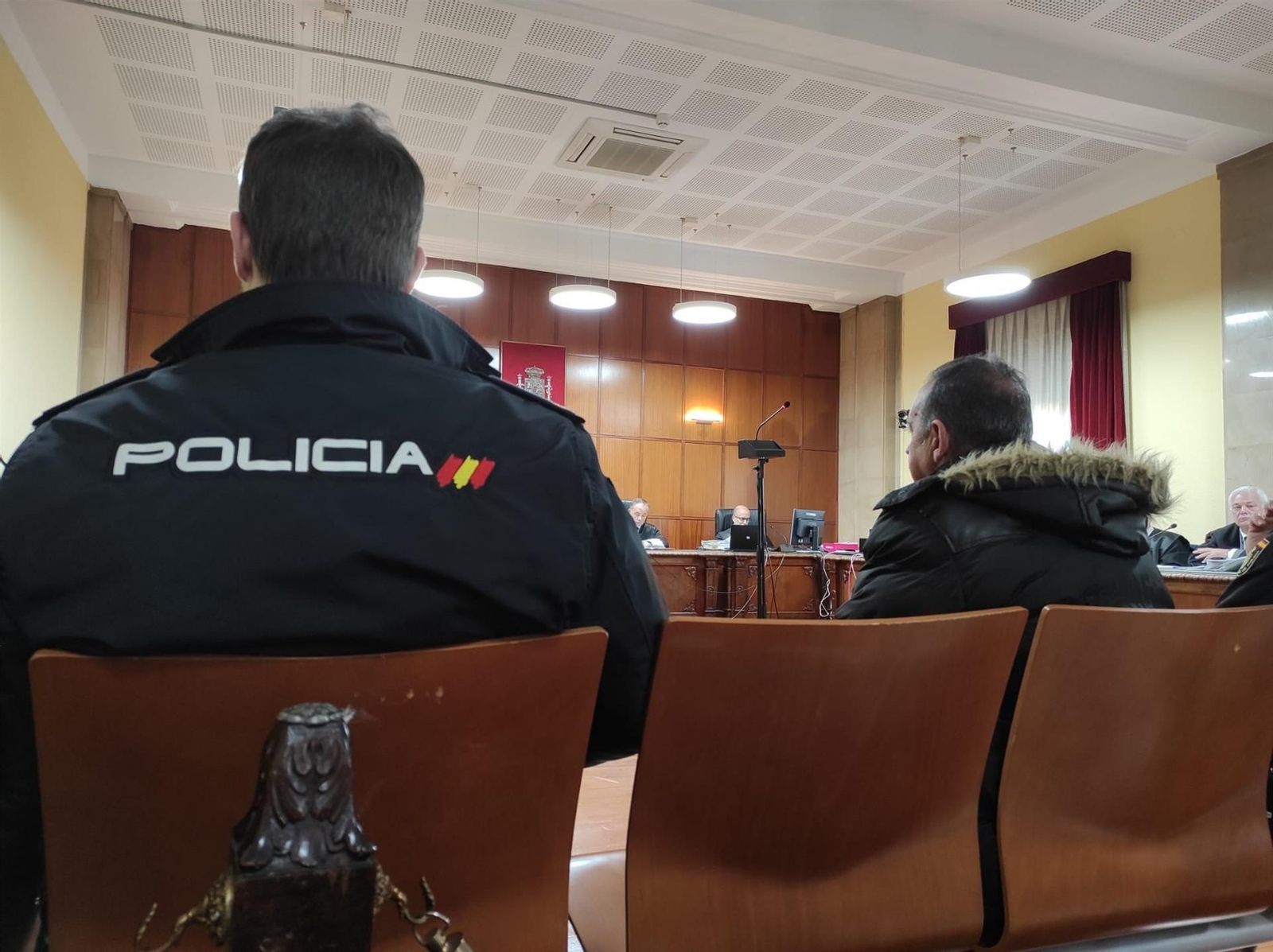 El acusado durante el juicio custodiado por agentes policiales.