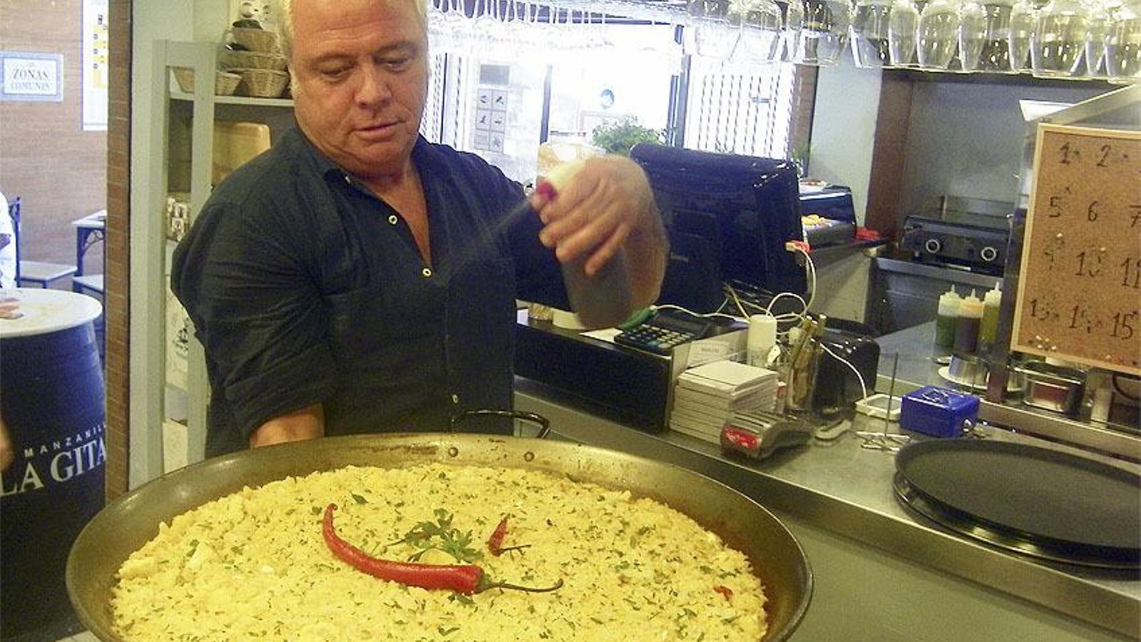 David Hidalgo rociando con vino uno de sus arroces David Hidalgo rociando con vino uno de sus arroces