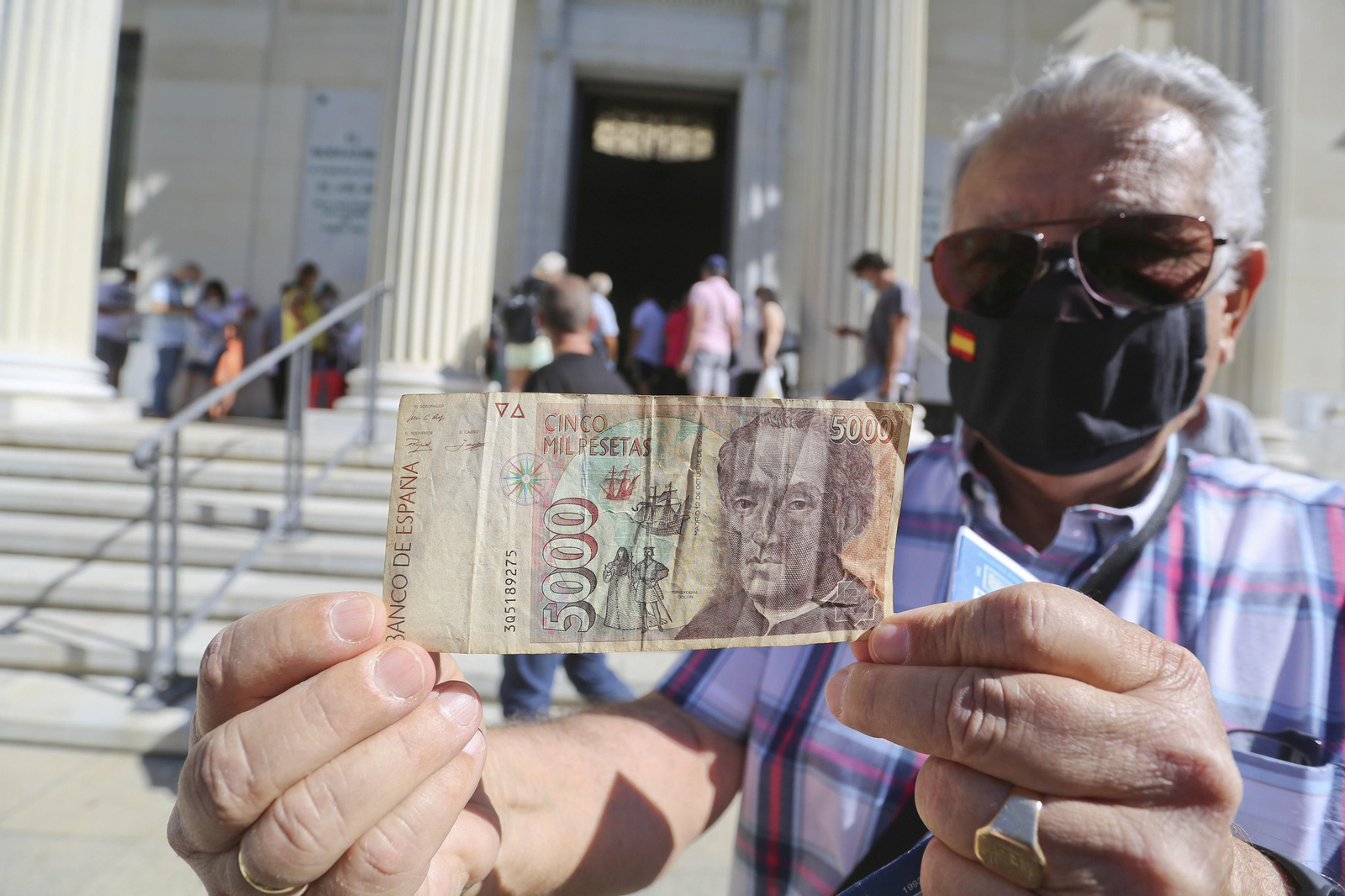 Un ciudadano sostiene un billete de 5.000 pesetas antes de canjearlo por euros