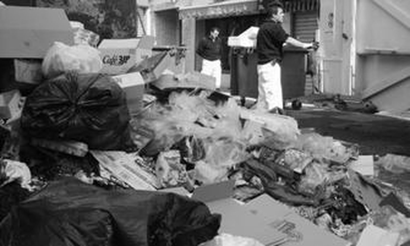 Dos operarios retiran ayer a mediodía la basura acumulada junto al mercado de La Concepción.