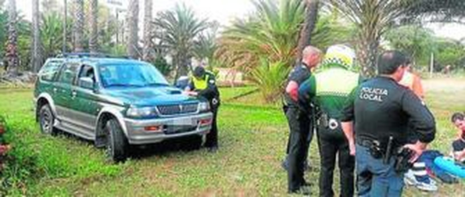 1. Un policía local toma notas sobre el vehículo de un compañero, ayer en el Parque Príncesa Sofía. 2. Los servicios médicos atienden a uno de los rumanos envueltos en la pelea, que sufrió una fractura en su pierna izquierda.