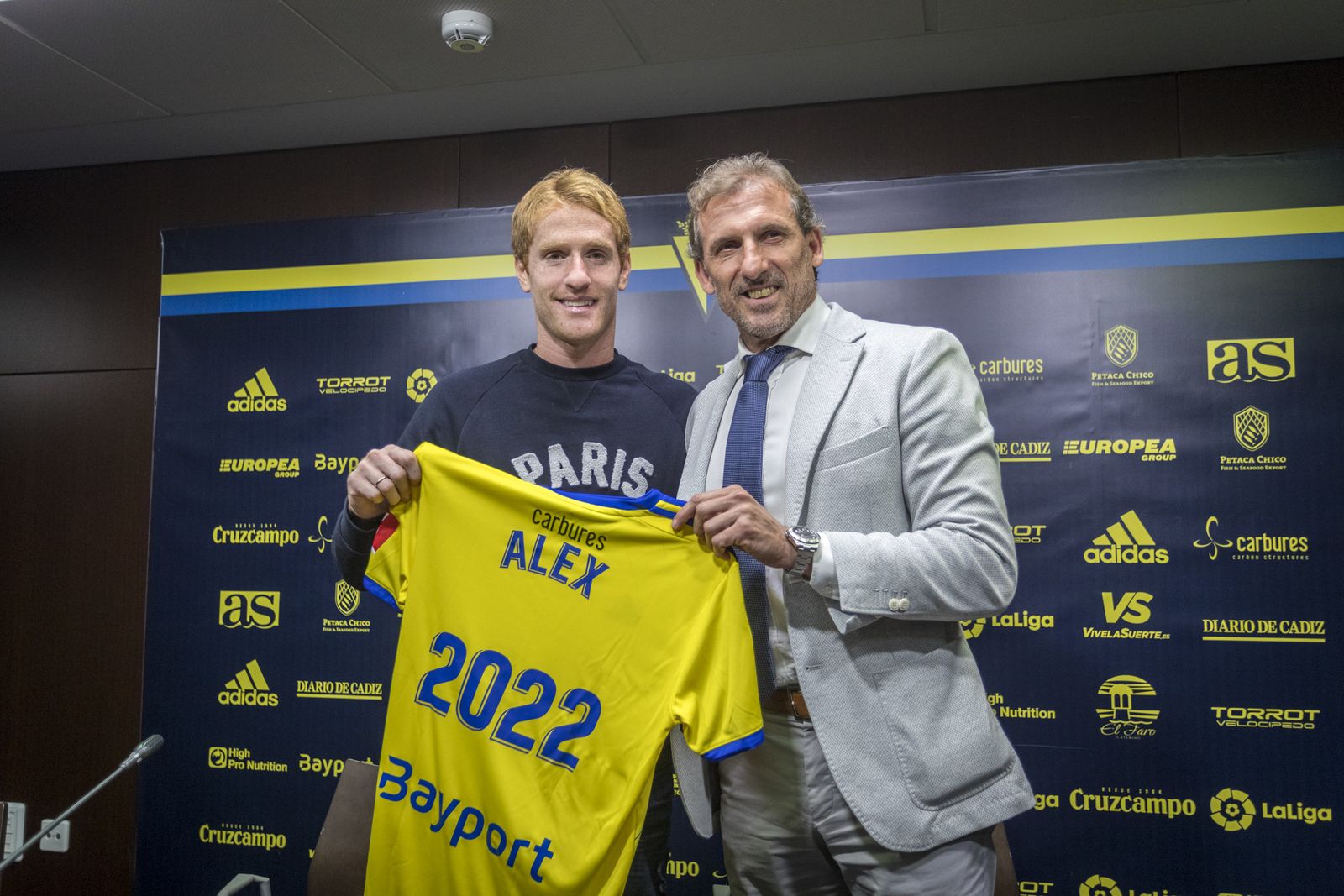 Álex Fernández y Óscar Arias sostienen la camiseta del jugador en la sala de prensa del Carranza.