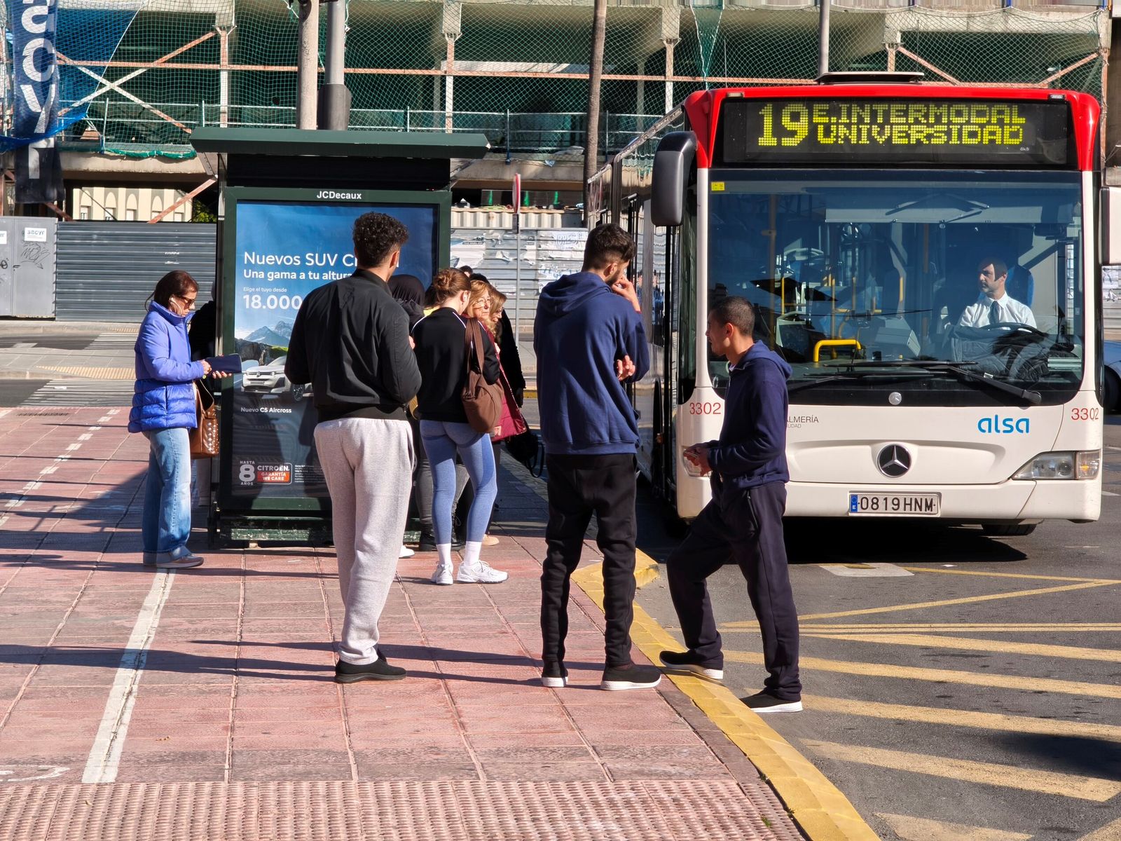 VArias personas esperan en la parada de la estación de trenes de Almería para subir al autobús.