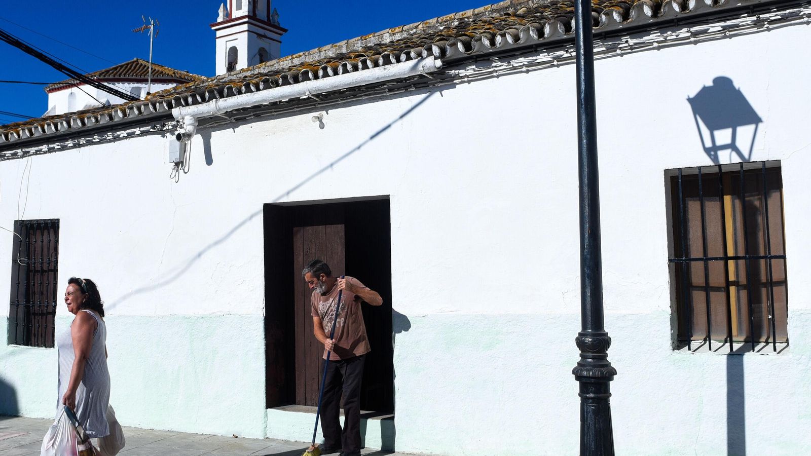 Un vecino del Garrobo limpiando la puerta de su casa.