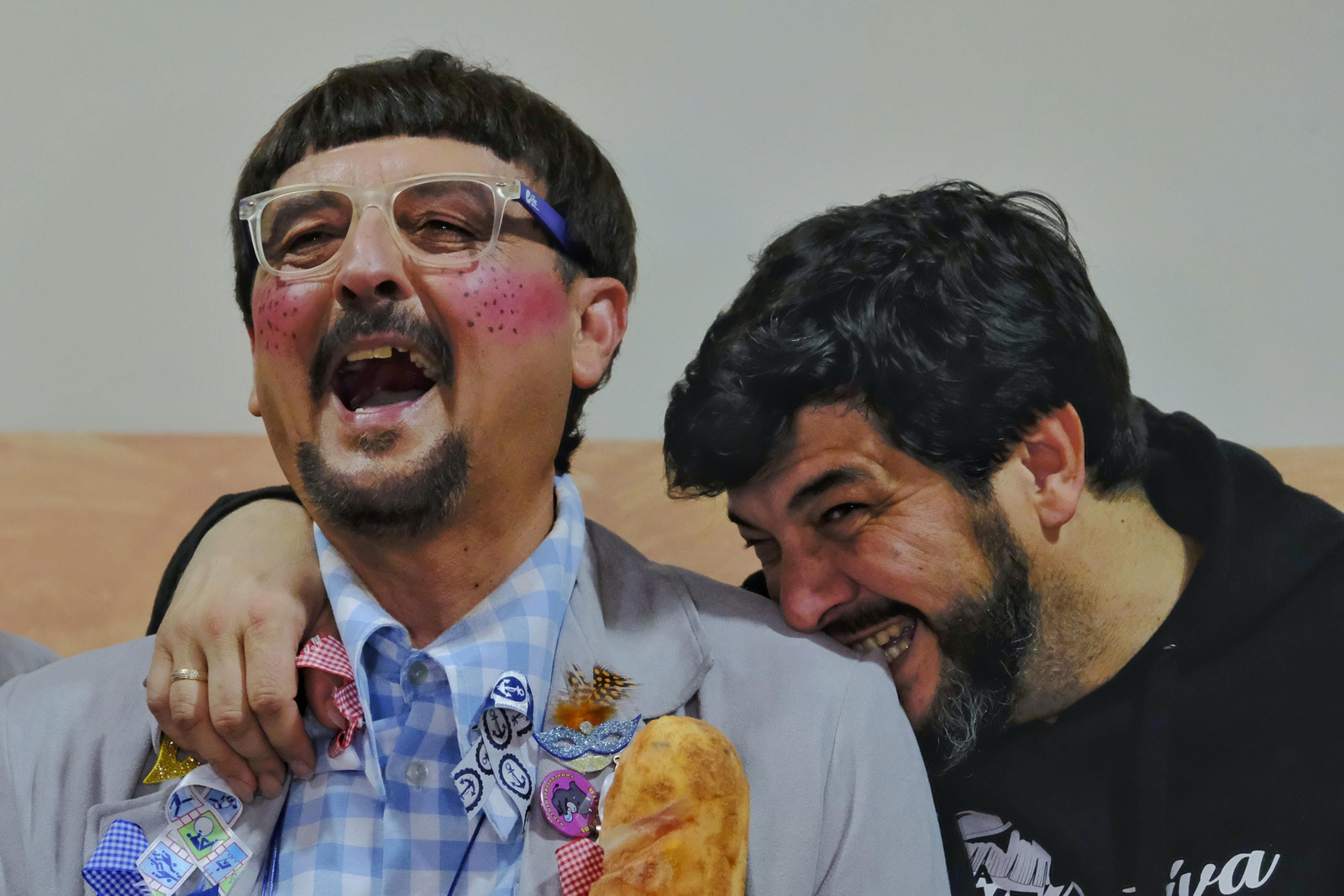 Quique Remolino bromea mordiendo el hombro de El Love mientras la chirigota se hace la foto de grupo en camerinos.