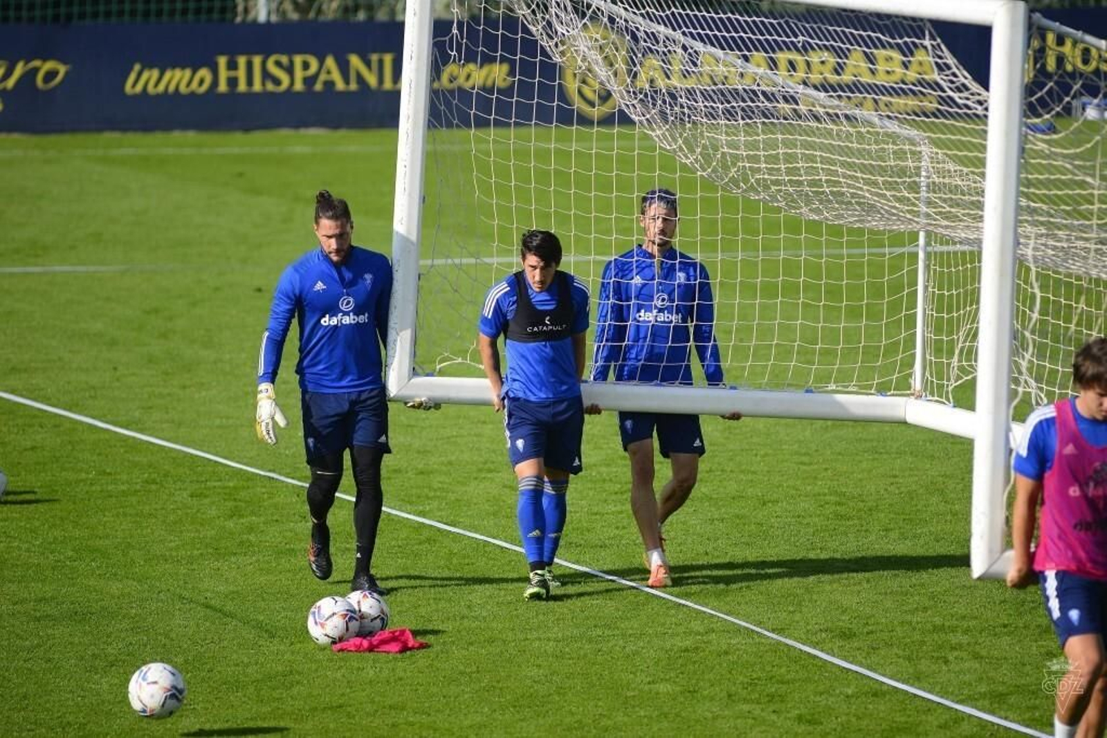 Jugadores del Cádiz CF trasladan una portería en El Rosal.