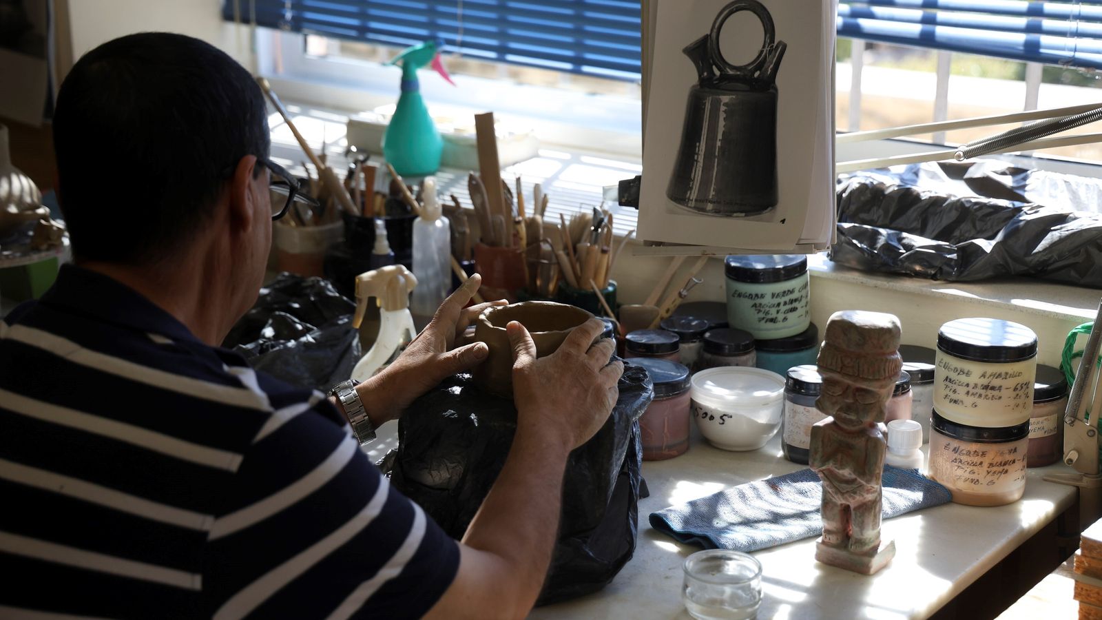 José modela un botijo de barro en el taller de Artes Plásticas.