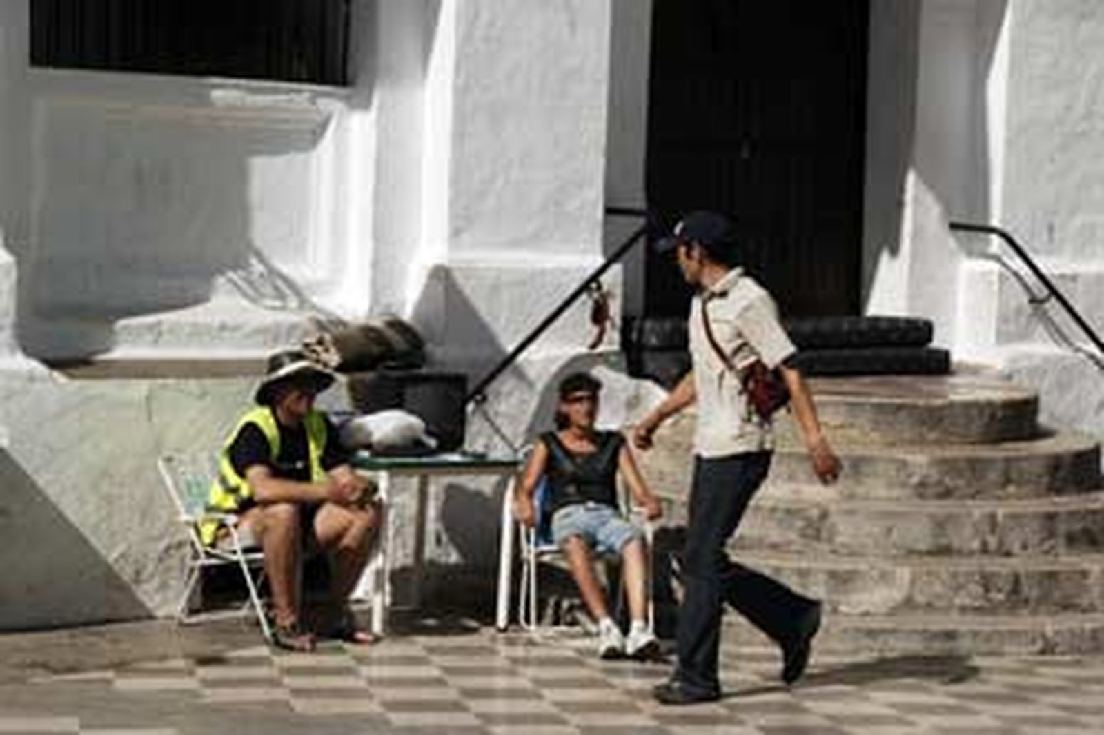 Un viandante mira a Francisco Adolfo Márquez y Eva Muñoz con todos sus utensilios ante el Ayuntamiento.