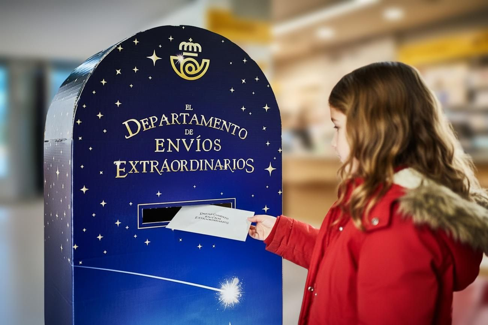 Una niña deposita su carta en uno de los buzones mágicos de Correos