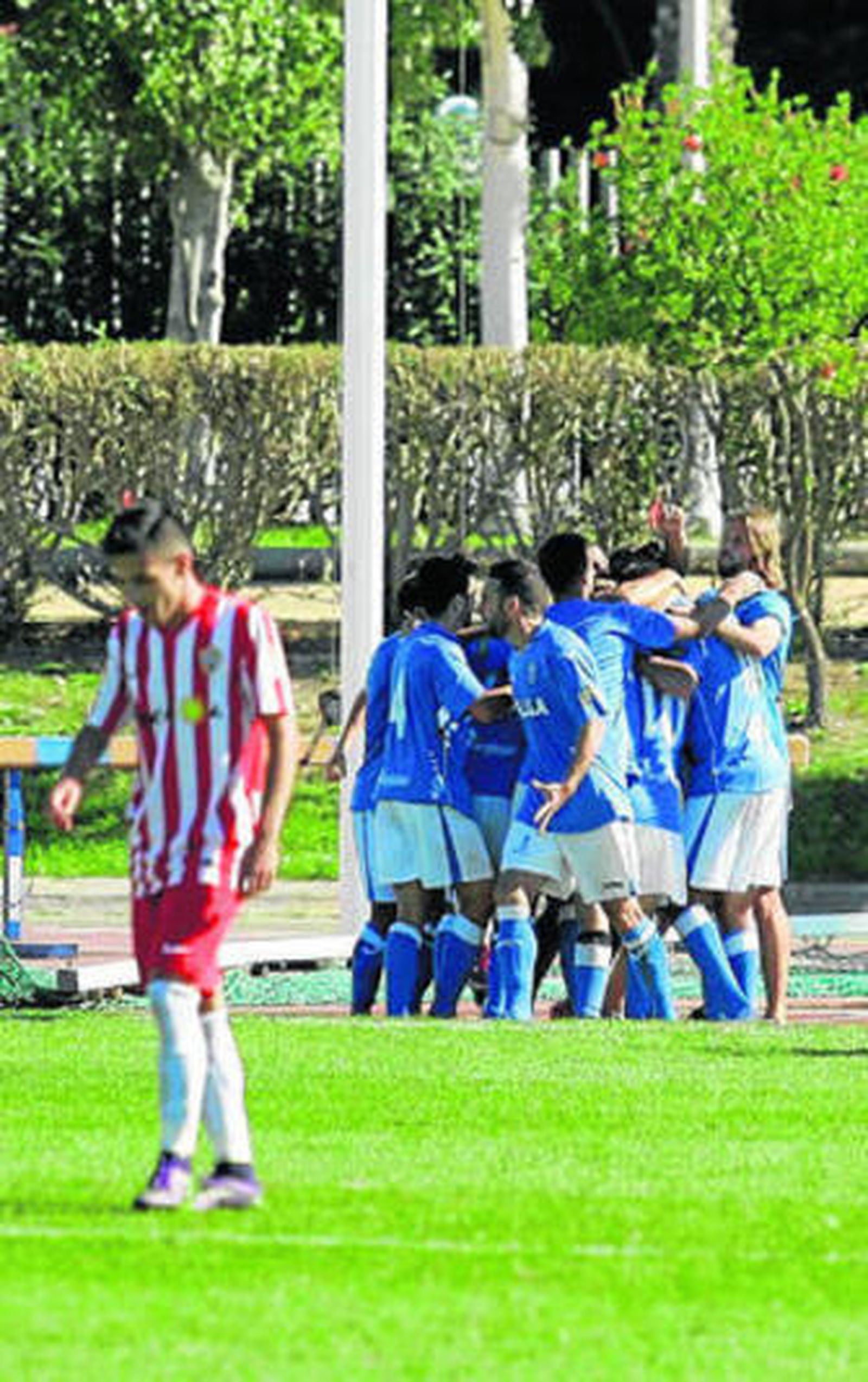 Piña de los futbolistas melillenses con el rojiblanco Guirao decepcionado en primer plano.
