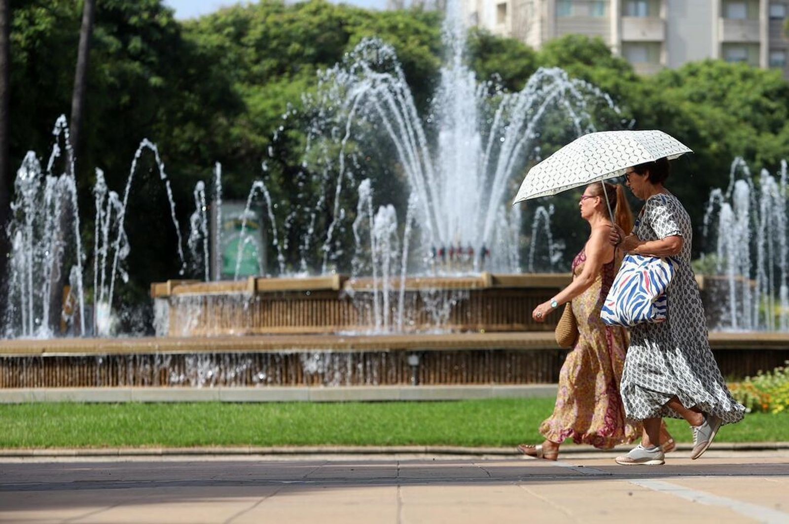 Dos mujeres se protegen del sol con un paraguas en la ciudad