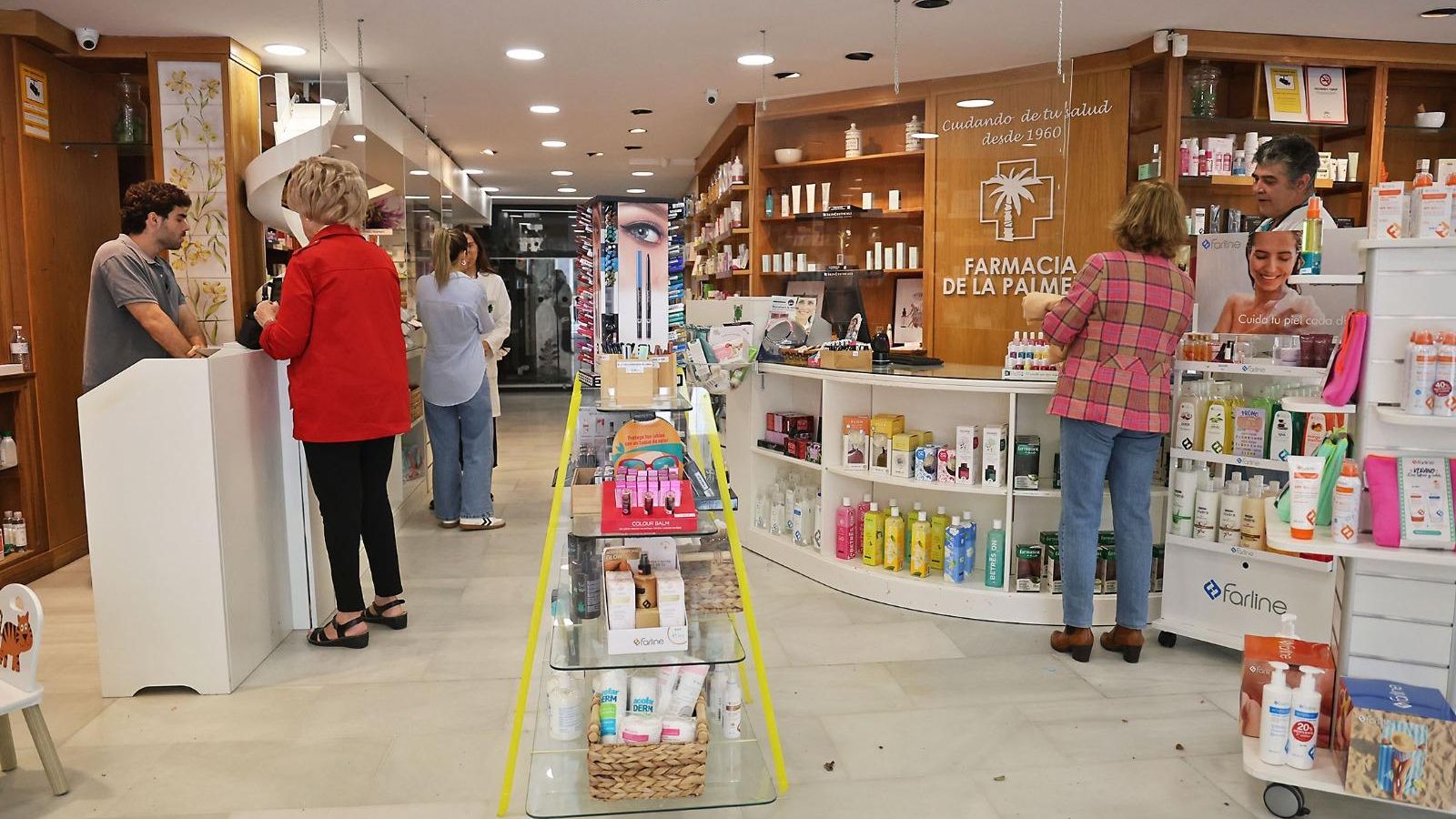 Clientes en una farmacia del centro de Huelva este martes.