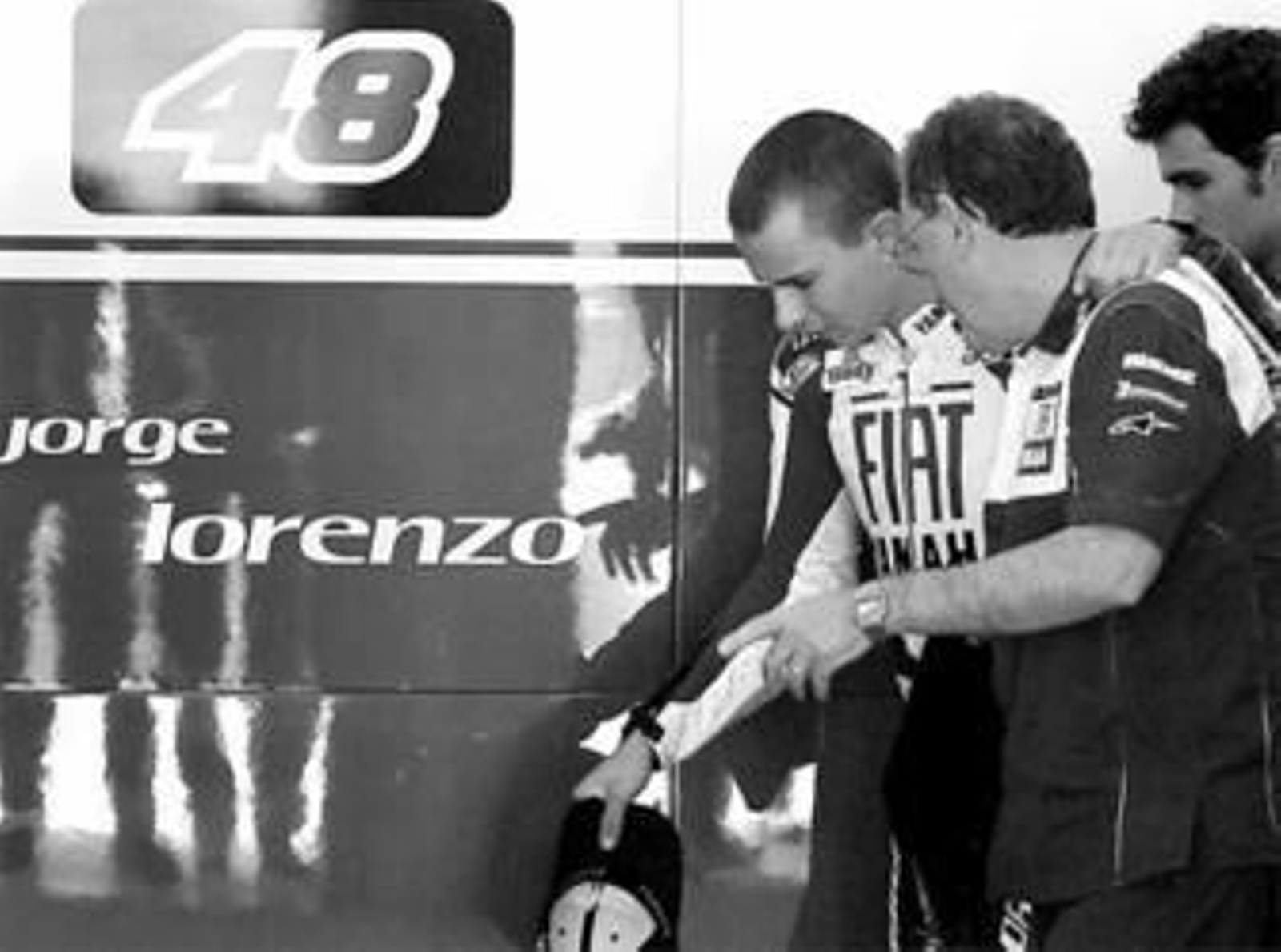 Miembros del equipo de Yamaha ayudan a Lorenzo en la zona de boxes.