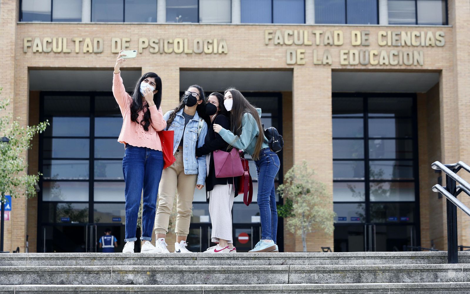 Estudiantes se hacen una foto frente a la Facultad de Psicología.