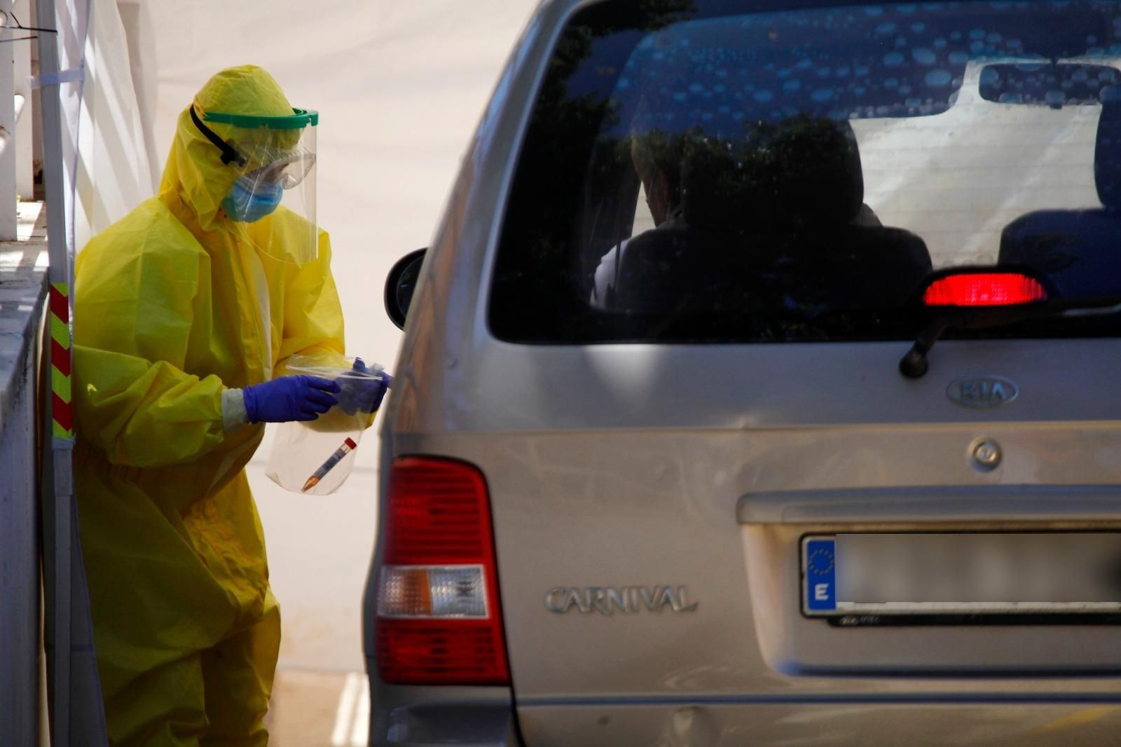Un sanitario realiza un test a un usuario que va en un vehículo.