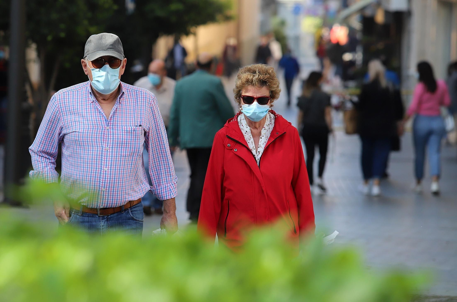 Dos personas con mascarilla paseando.