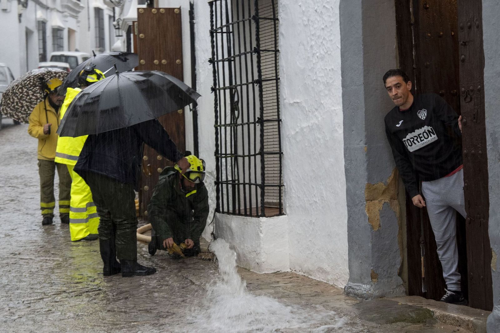 Vecinos de Grazalema, el miércoles de la semana pasada, intentando achicar agua de sus casas.