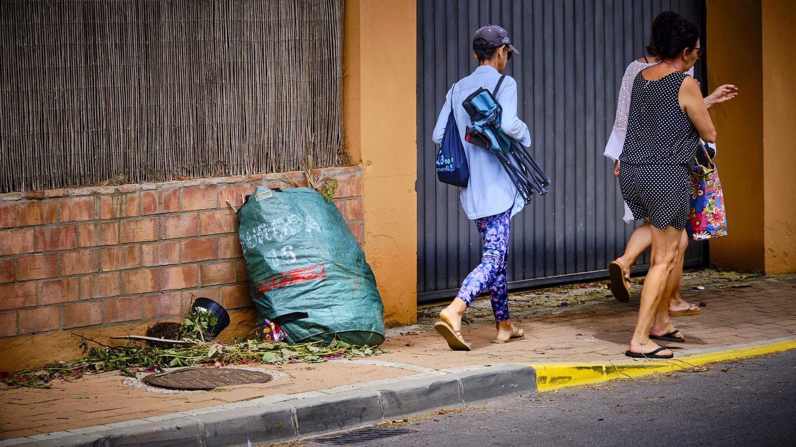 Bolsas de basura y restos de poda, acumuladas en una de las calles de la urbanización.