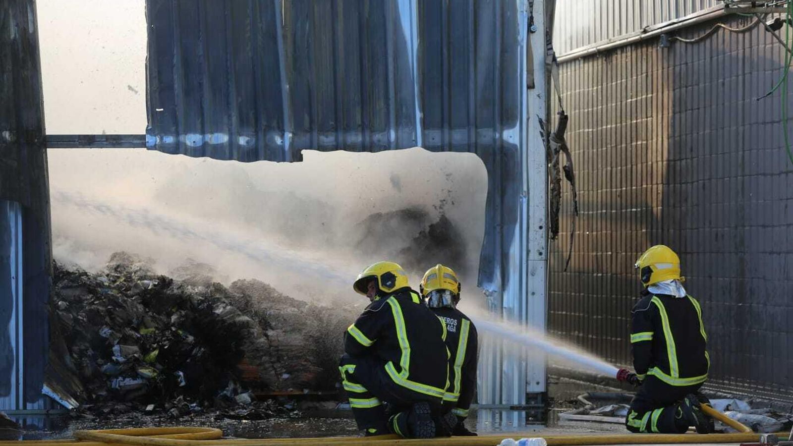 Bomberos sofocan las llamas en la nave del polígono Guadalhorce incendiada.