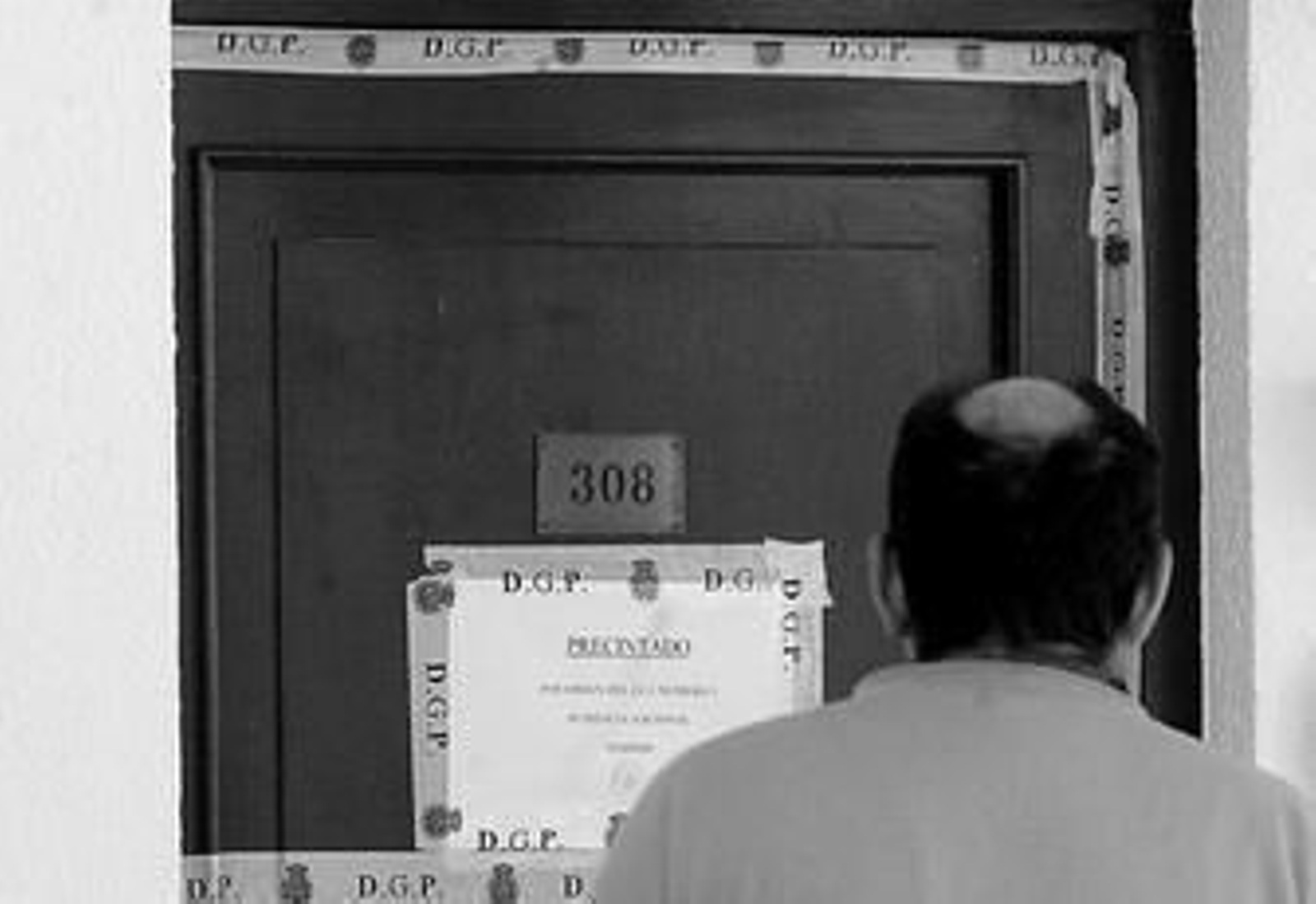 Un vecino mira el precinto de la vivienda de Ixone Fernández Bustillo en febrero de 2005.