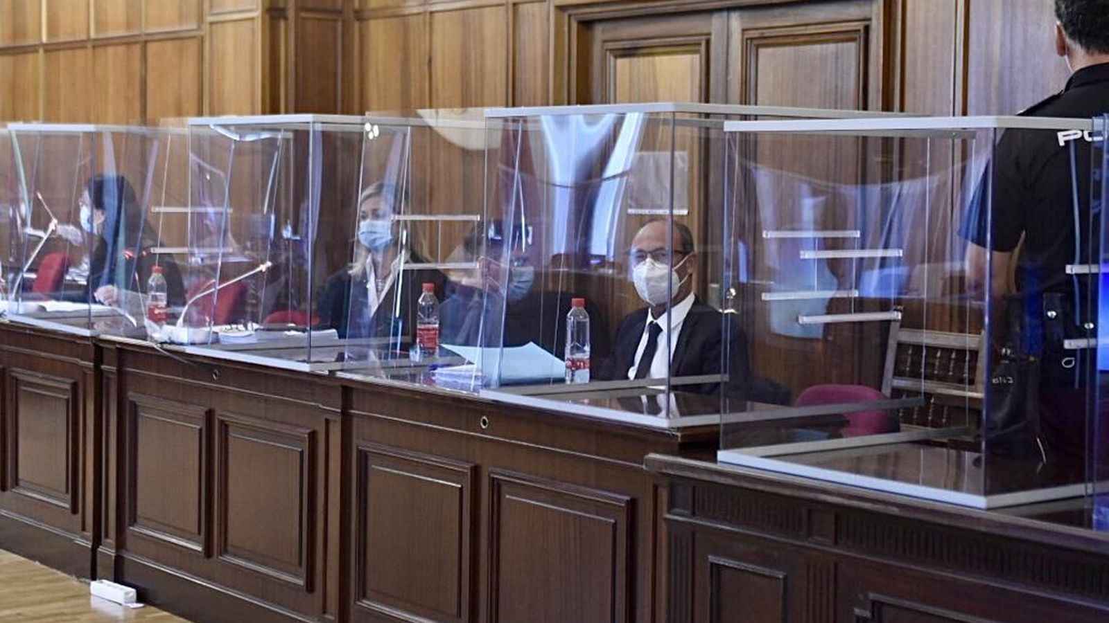 Una imagen de los estrados, protegidos con mamparas, y tras ellas, la fiscal, el acusado y los abogados de la defensa.