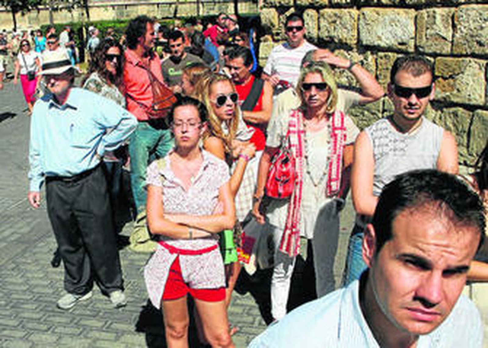 Turistas guardan cola para entrar en el Alcázar, uno de los monumentos más visitados de la capital andaluza.