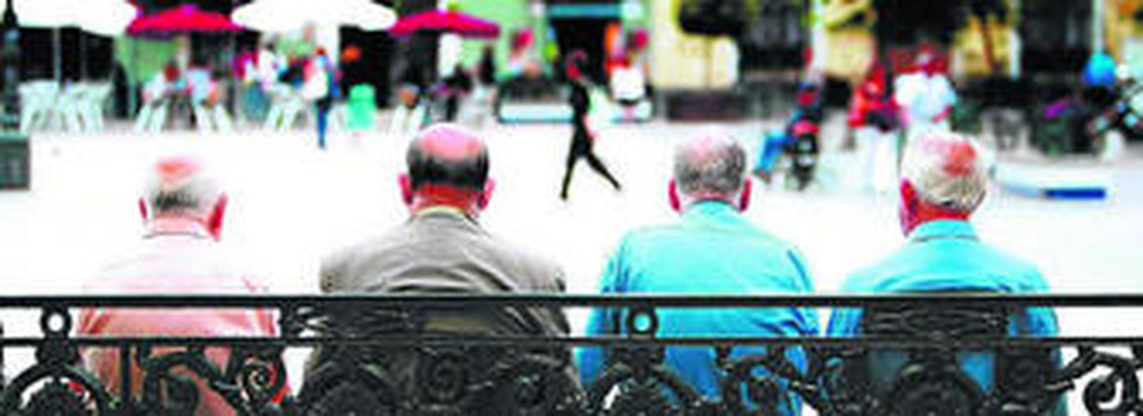 Cuatro ancianos sentados en un banco en la plaza de San Antonio de Cádiz.