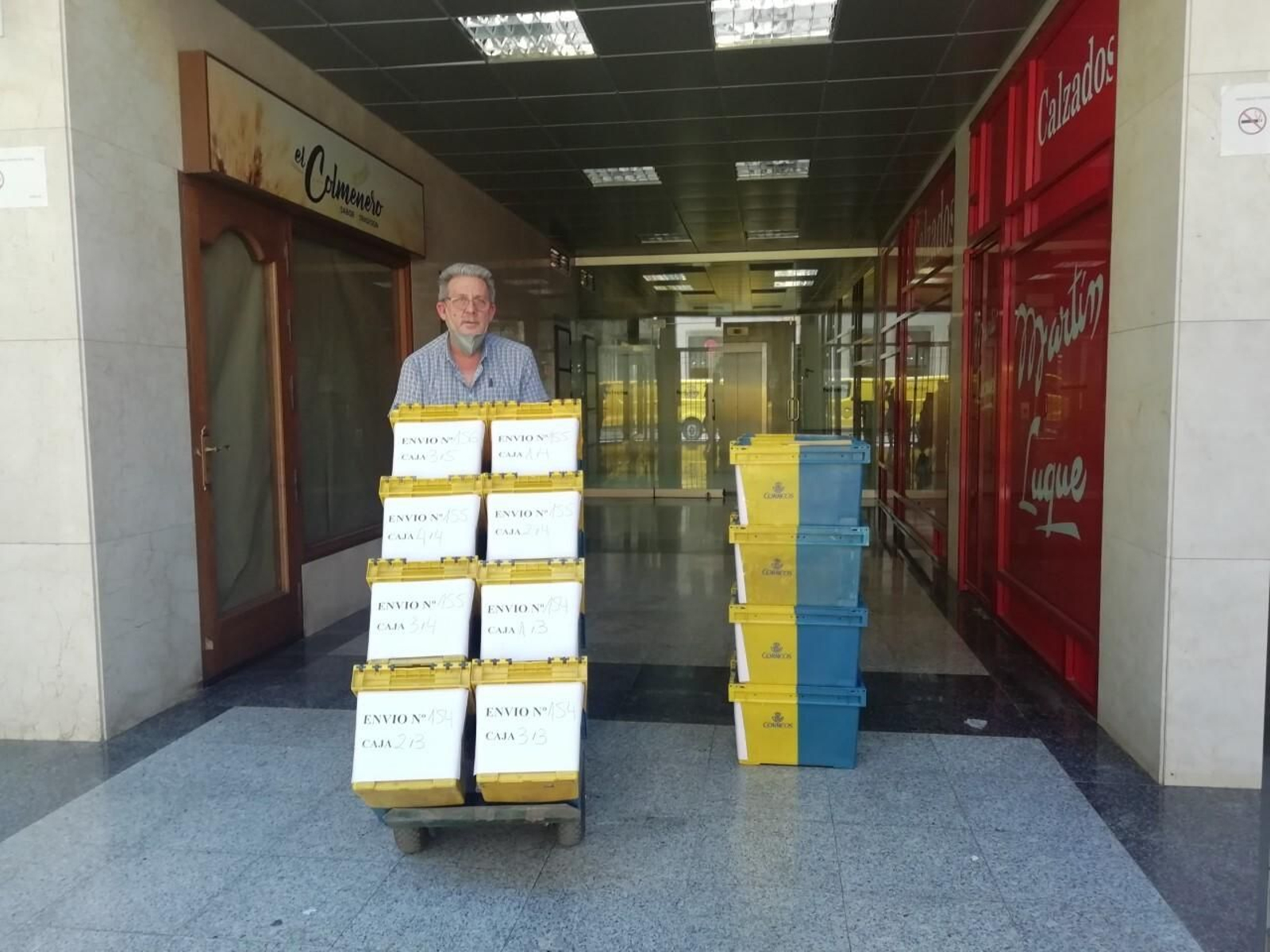 Un funcionario del Instituto Nacional de Estadística con cajas de papeletas para el voto por correo.