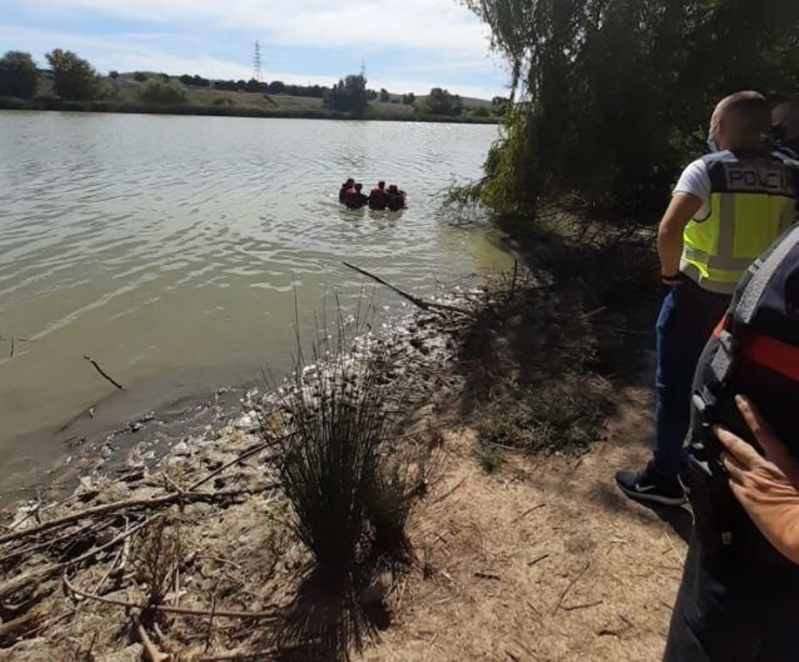 Los bomberos rescatan el cádaver en el Guadalquivir.