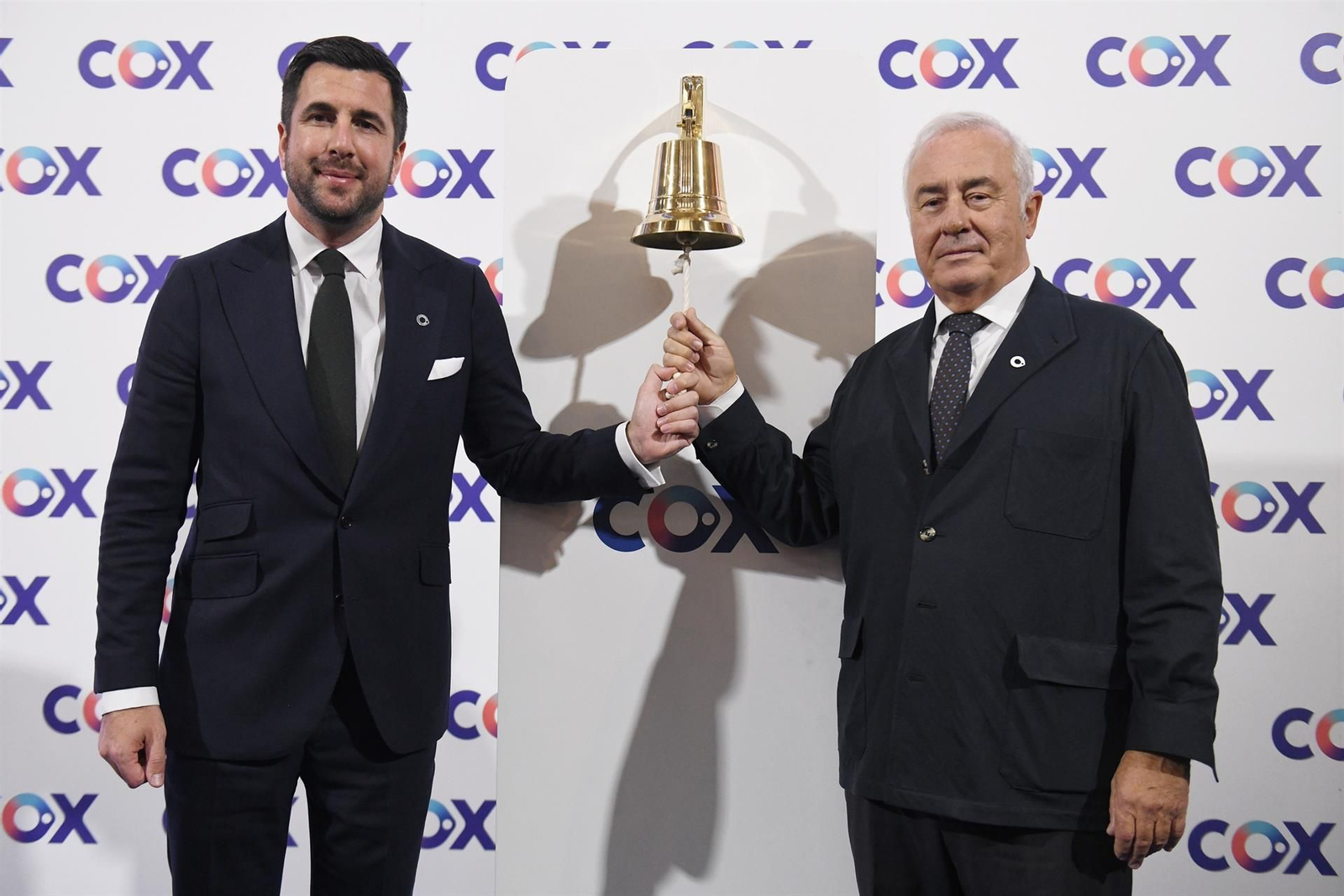 Uno de los accionistas de Cox, Alberto Zardoya, de la familia que fundó el grupo de ascensores Zardoya (i) y el CEO de Cox, Enrique Riquelme (d), tocan la campana durante la ceremonia de salida a Bolsa de Cox.