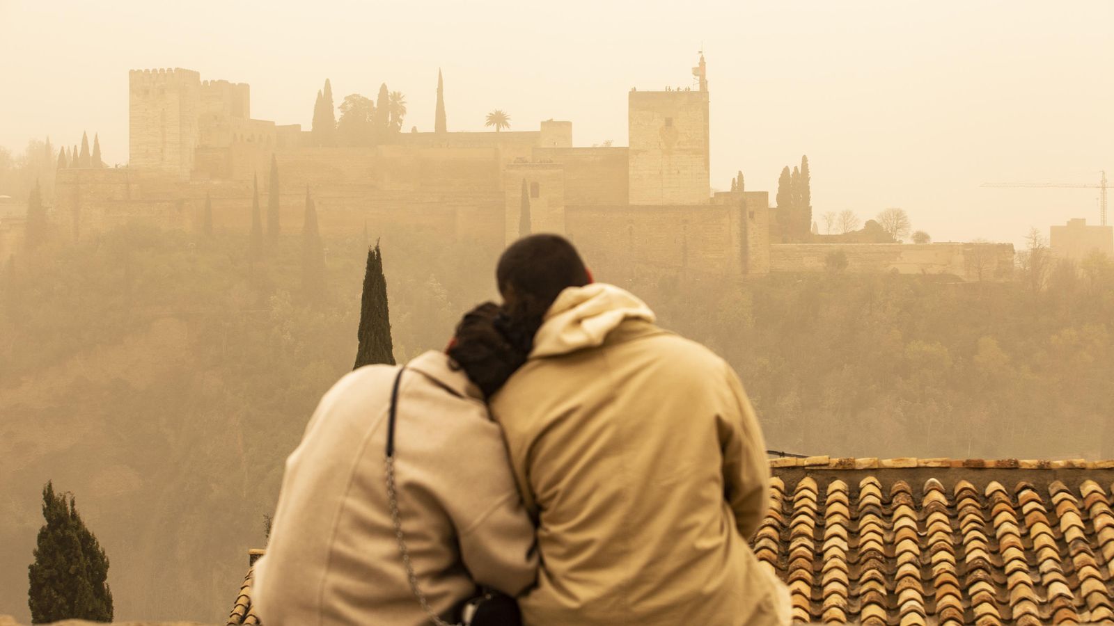Una pareja contempla la Alhambra en el episodio de calima de 2022