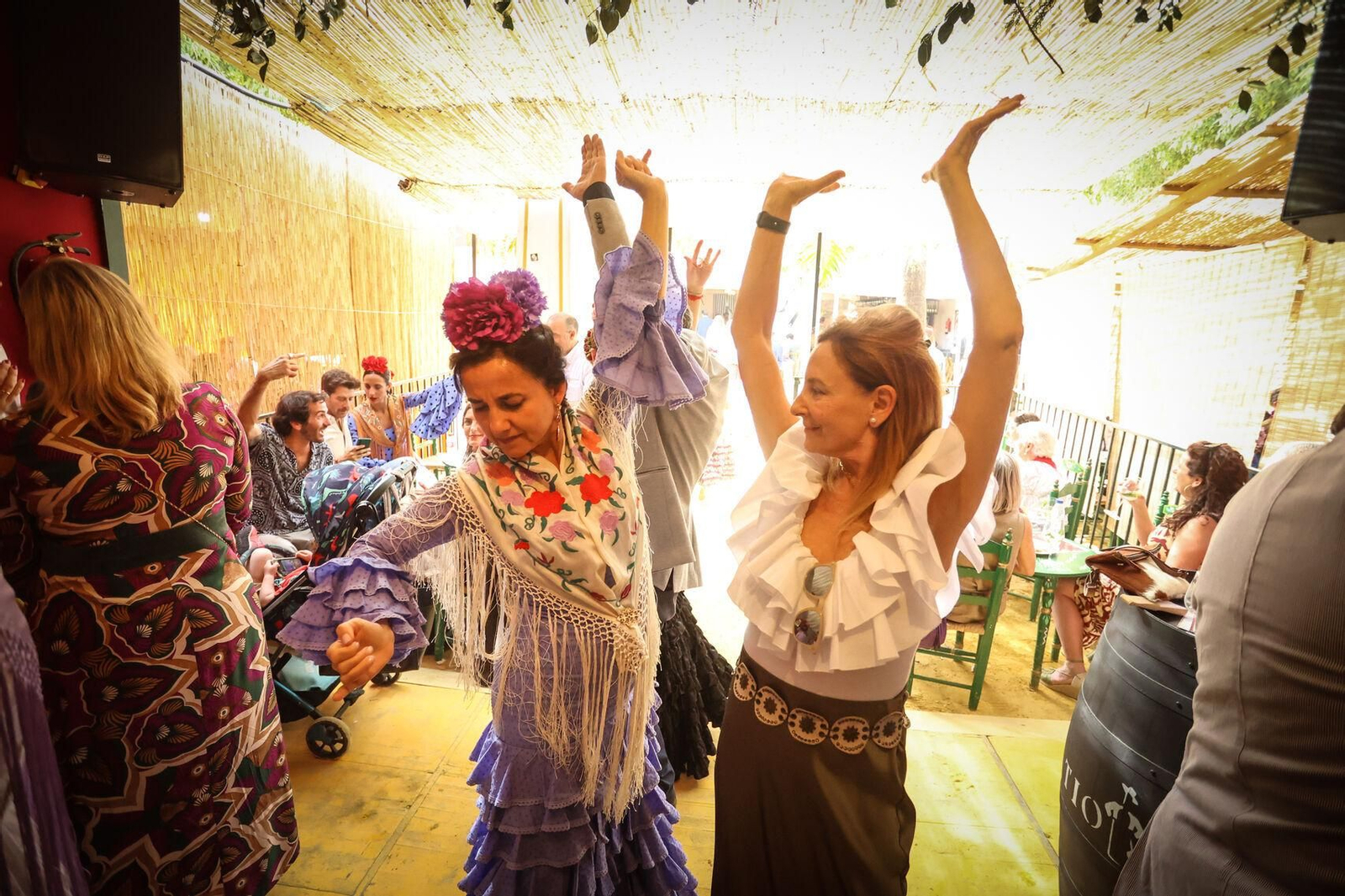 Dos mujeres, bailando sevillanas en una caseta.