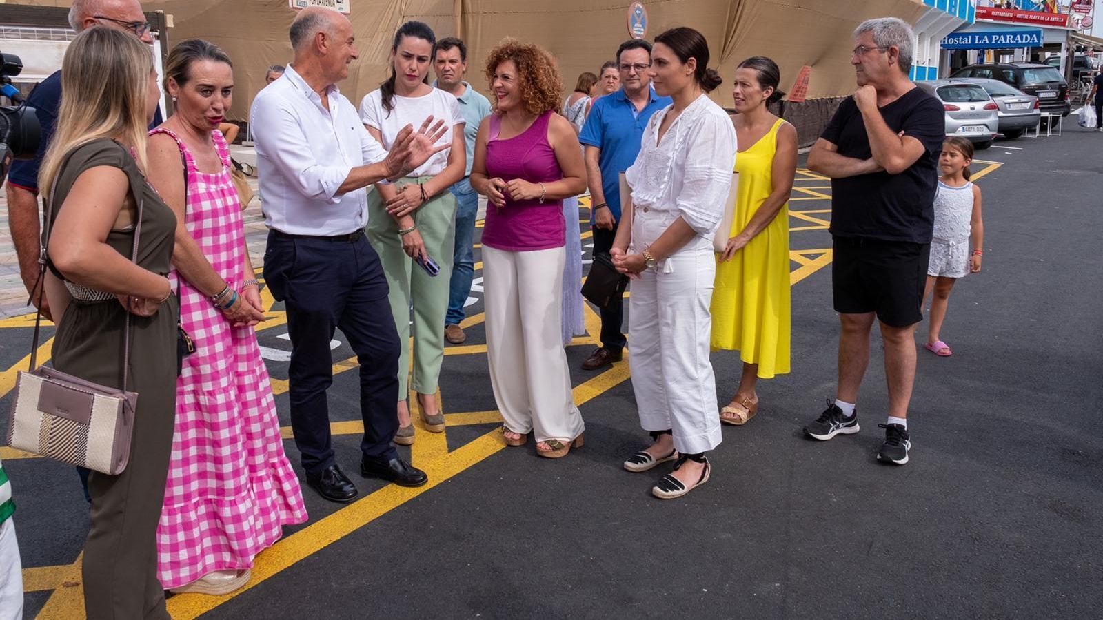 Varias personas se interesan por las explicaciones de las autoridades competentes.