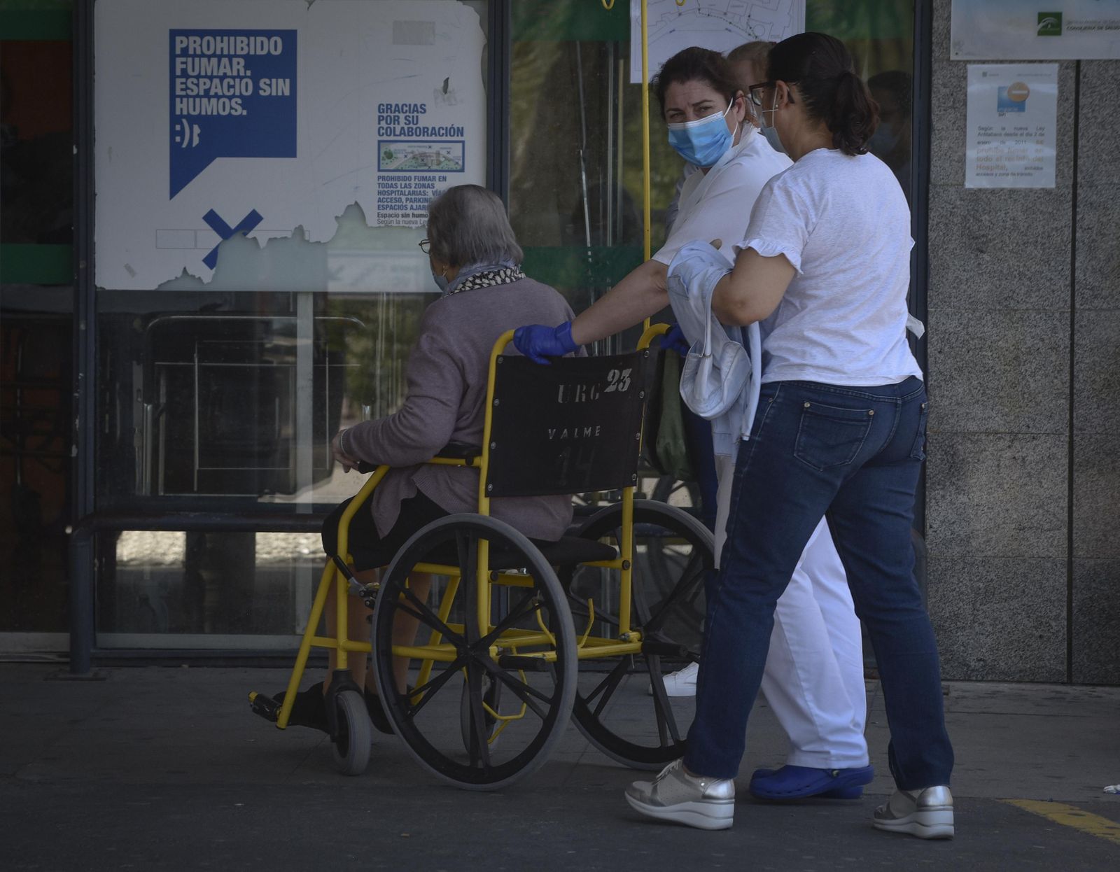 Sanitarios y familiares acompañan a una paciente a las puertas del Hospital de Valme.