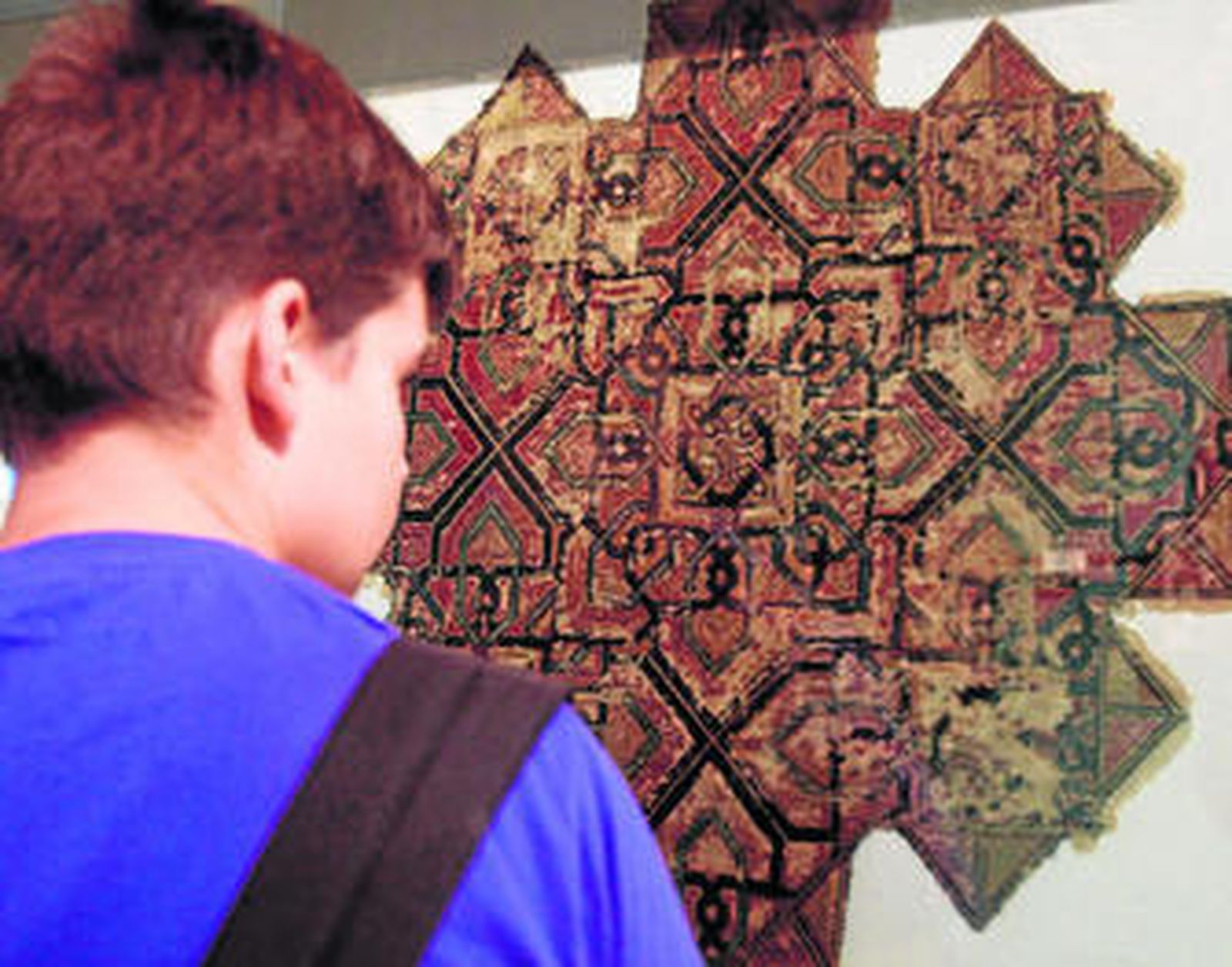 1. Un vistante contempla una de las piezas más llamativas que se exponen en la Alhambra hasta el próximo mes de diciembre.  2 y 5. La exposición contiene un rico material interactivo para ayudar a compreder tanto el virtuosismo de la técnica textil como la riqueza de sus frutos. 3 y 4. Todos los tejidos expuestos son del periodo nazarí pero la mayoría proceden de territorios castellanos.