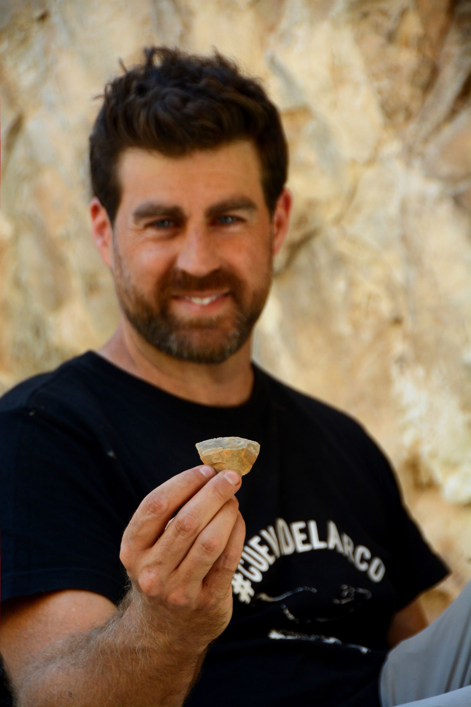 Uno de los investigadores muestra un trozo de hueso