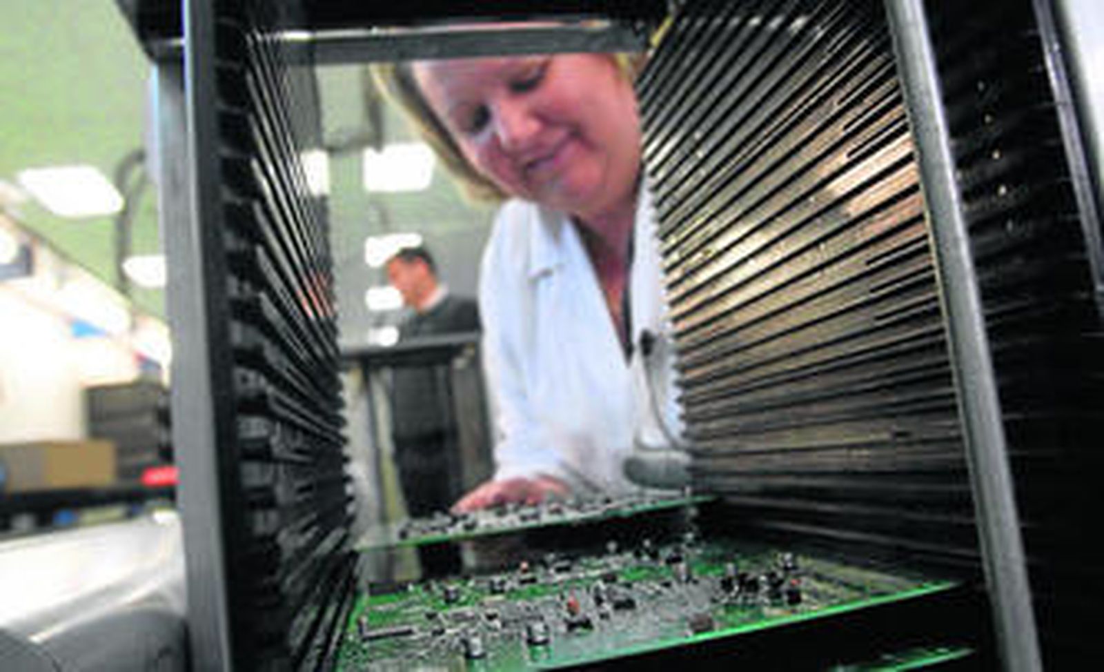 Una trabajadora de la empresa malagueña Sogecam, que vende teléfonos públicos en Argentina, manipula unas placas.