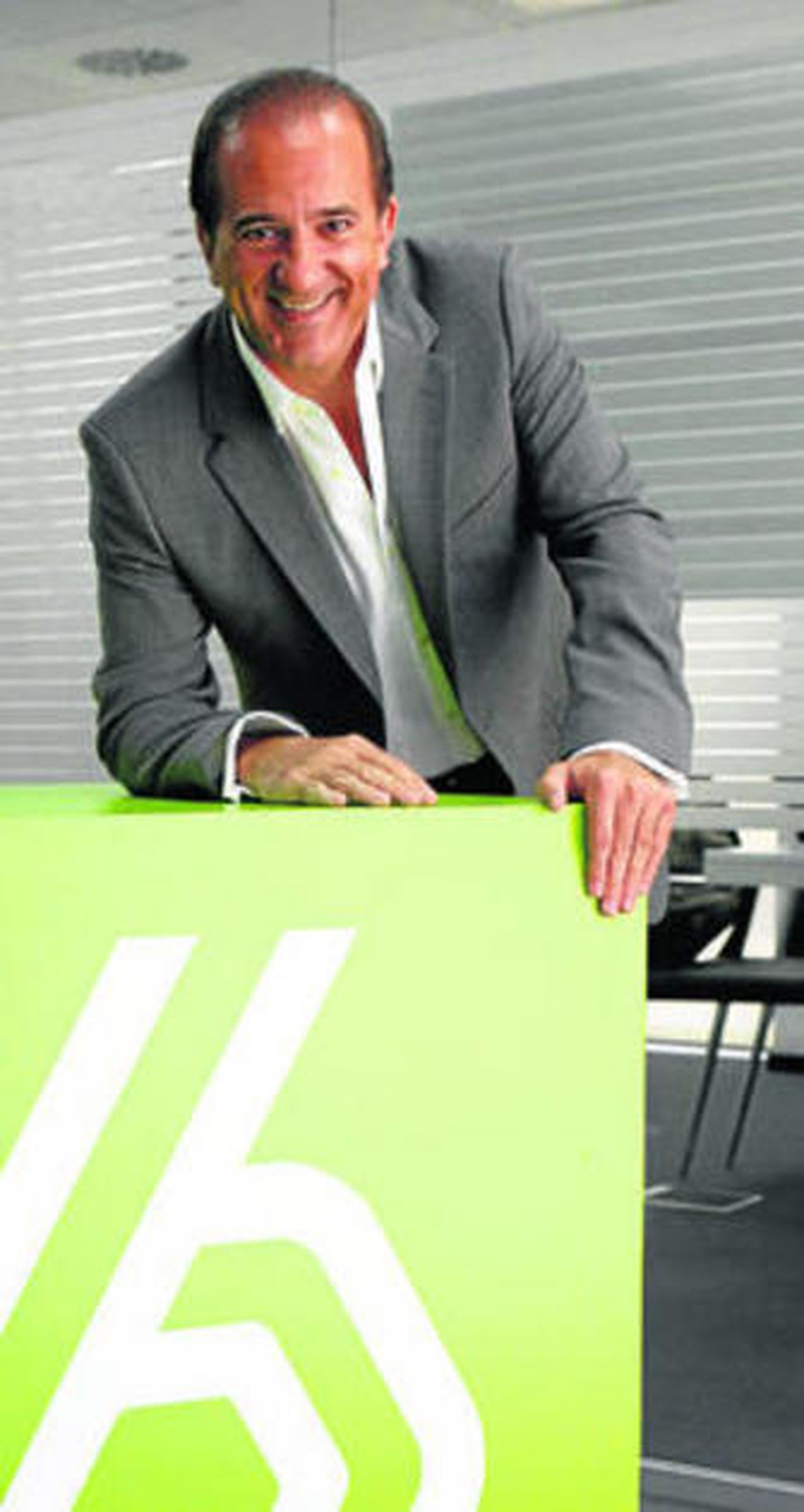José Miguel Contreras ante el logotipo de su cadena.