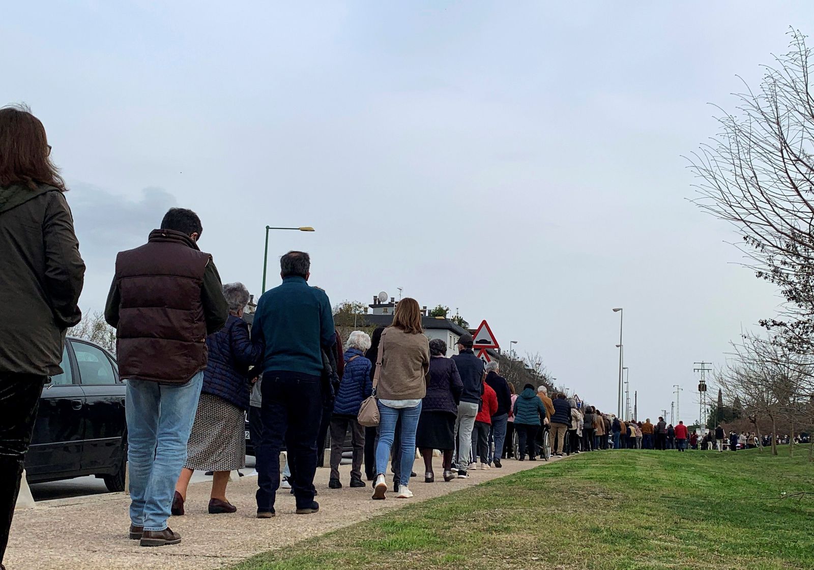 Larga cola de personas en Los Bermejales, donde han sido citados para vacunarse 1.500 octogenarios.