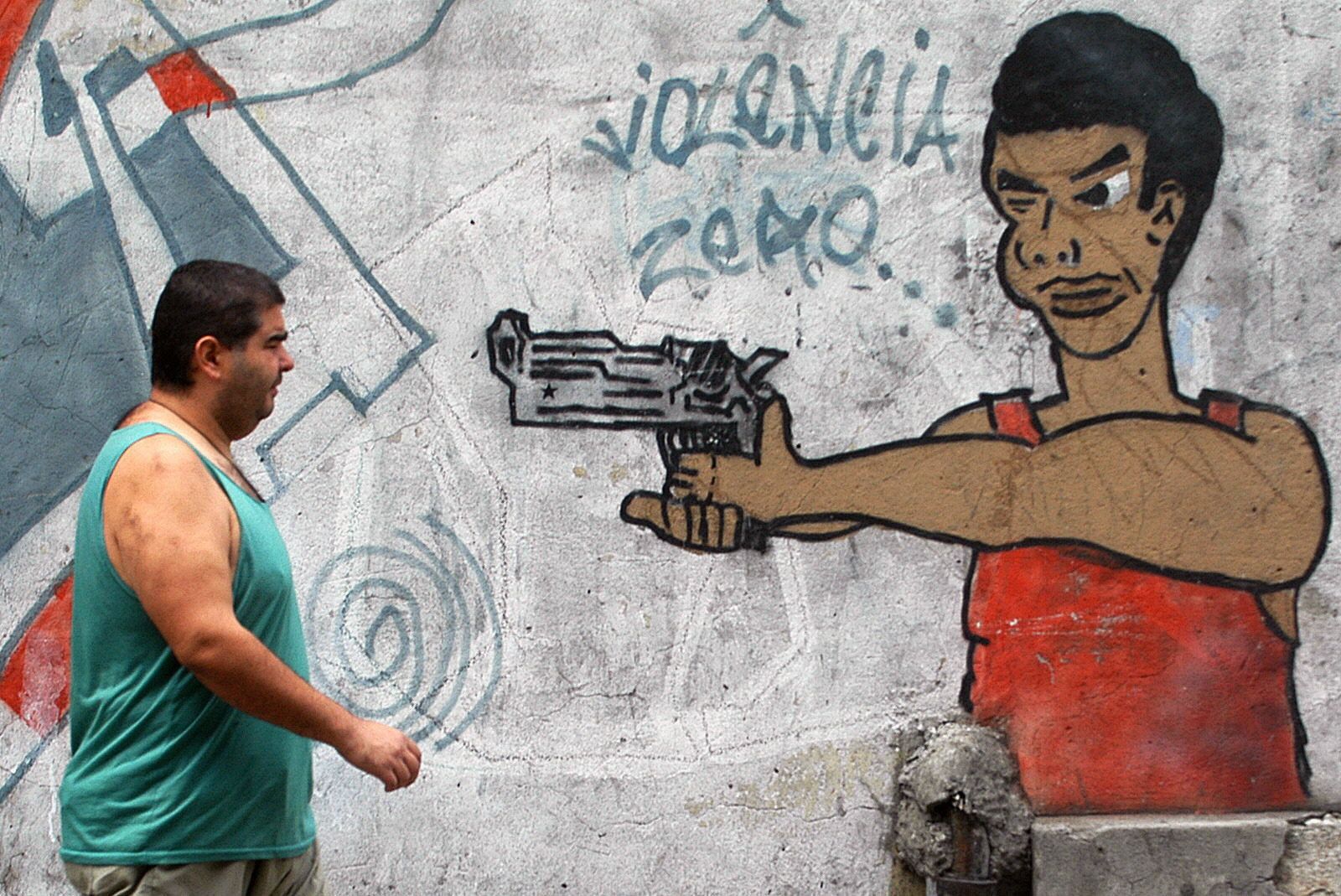 Un hombre pasa junto a un grafiti en un barrio de Río de Janeiro