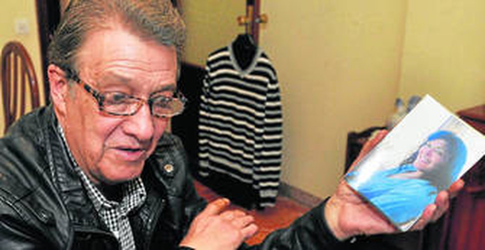 Isidro Sacristán, ex pareja de la víctima, muestra una fotografía de ella, ayer en su casa de la Macarena.
