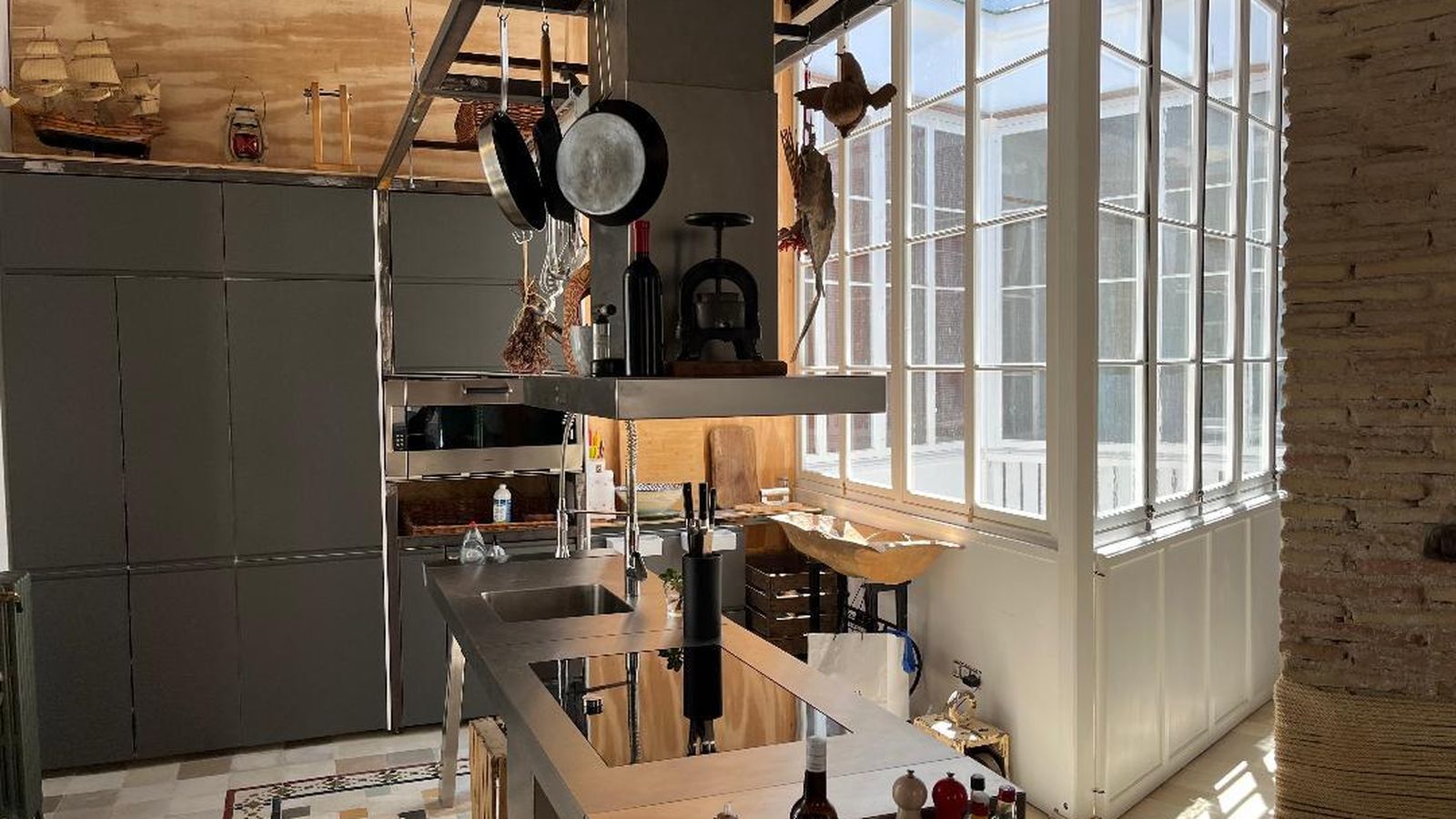 El mobiliario de cocina es gris metálico con una mesa de acero inoxidable de la fima Bulthaup.