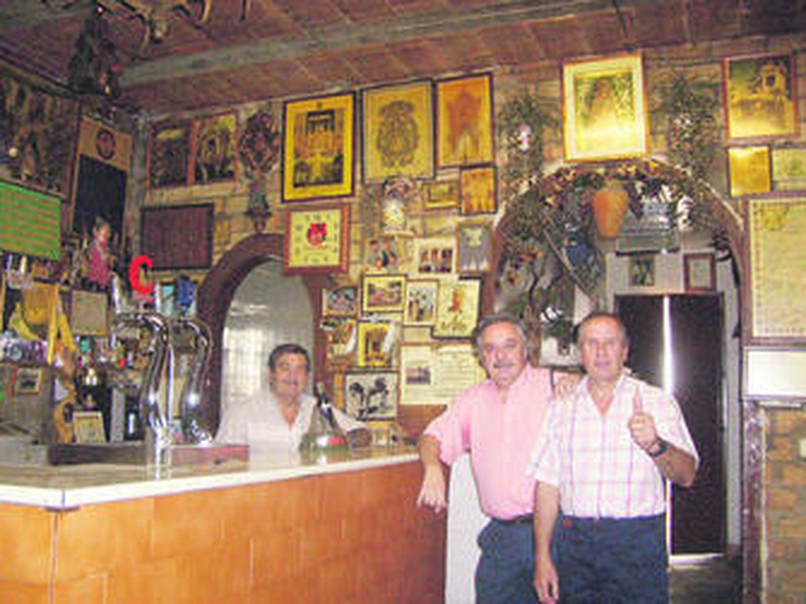 Bartolomé Arcos, dentro de la barra, posa junto a Ismael Yebra (en el centro), fiel cliente y amigo.