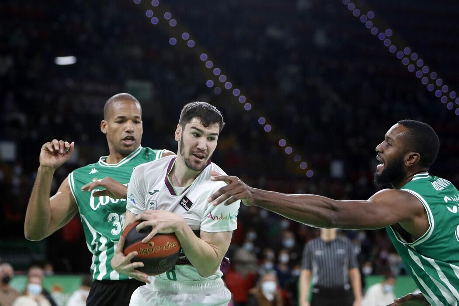 Darío Brizuela, entre dos rivales.