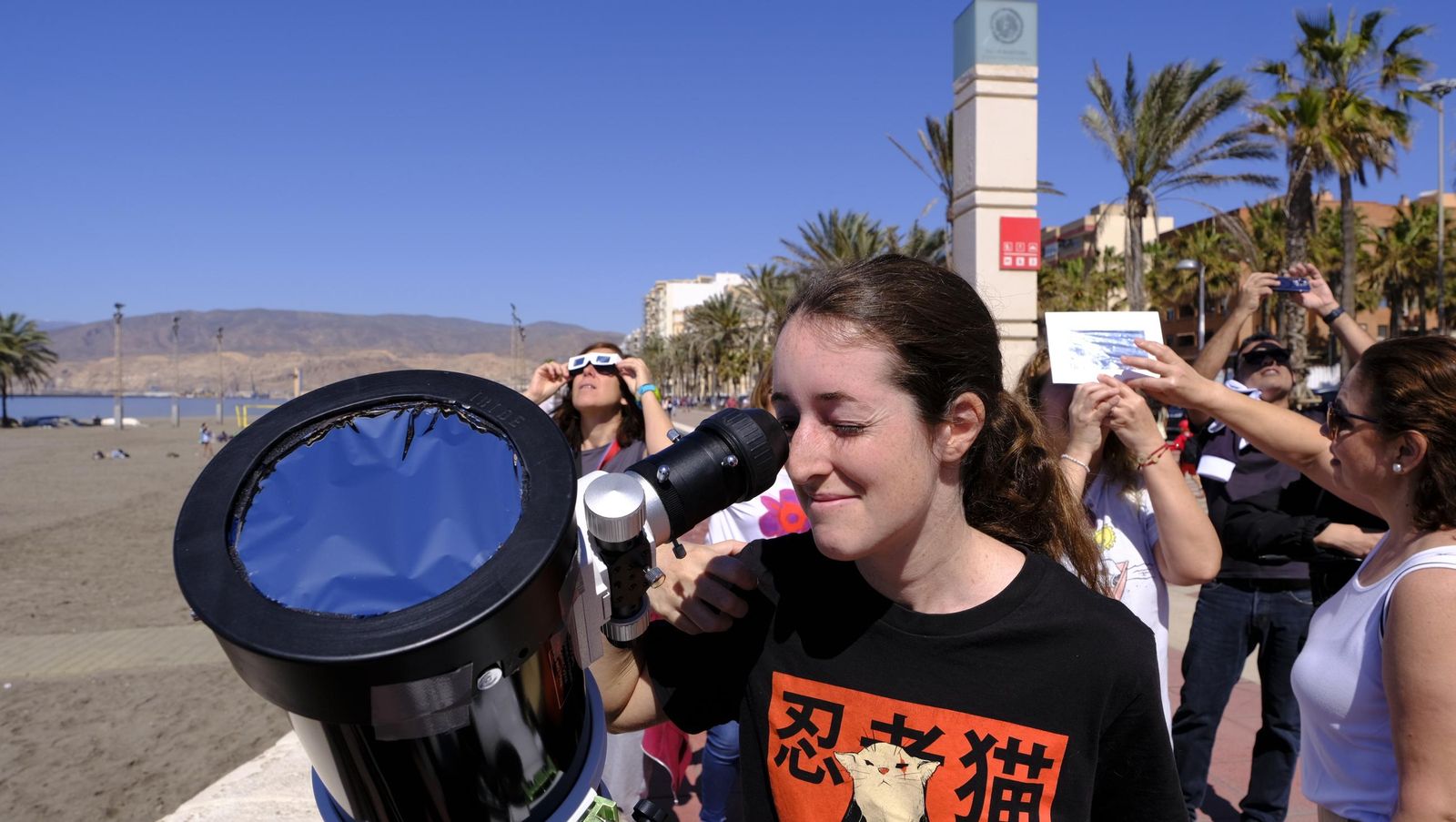Almería observa el eclipse solar desde el Paseo Marítimo, en imágenes